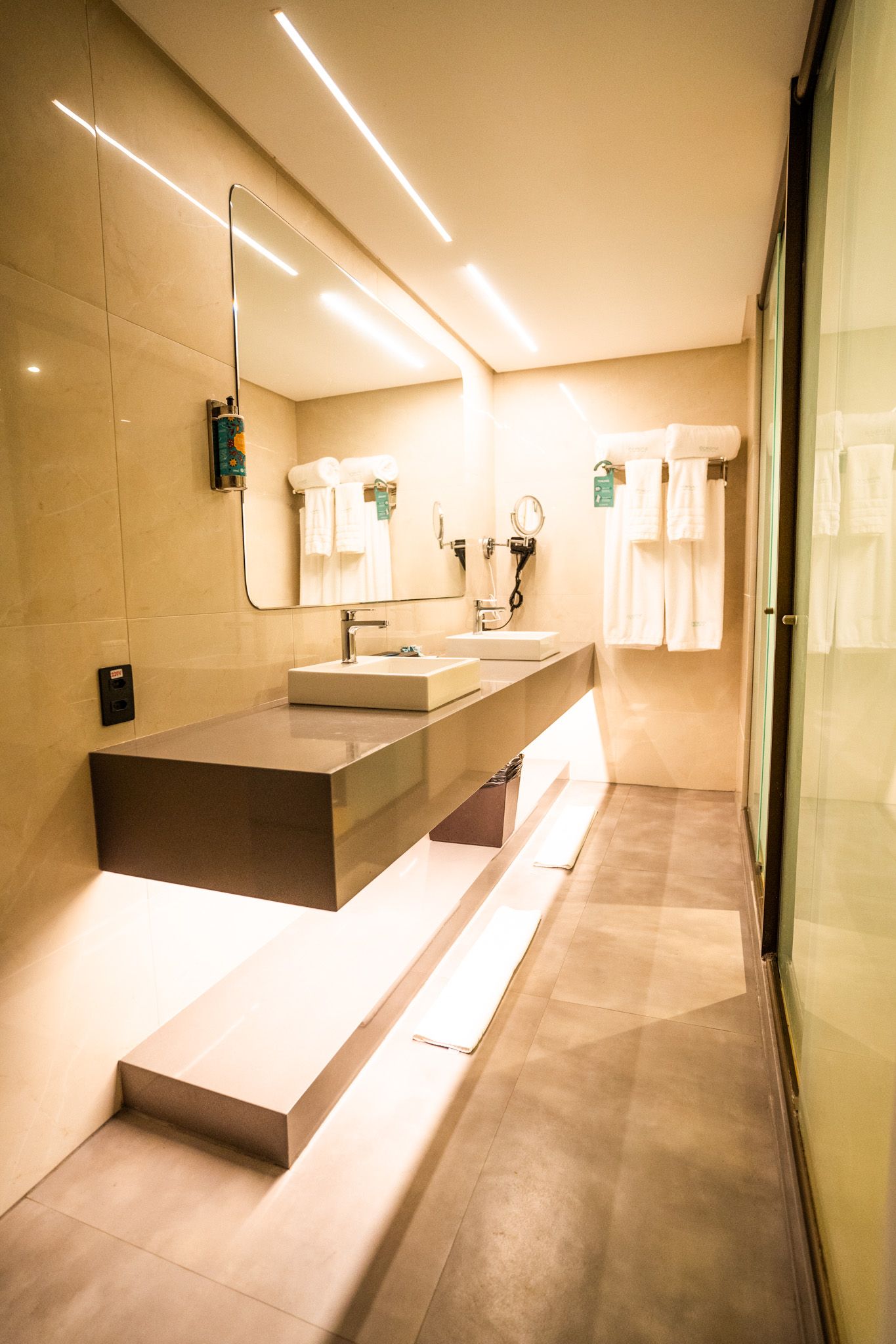 Um banheiro com duas pias e um espelho