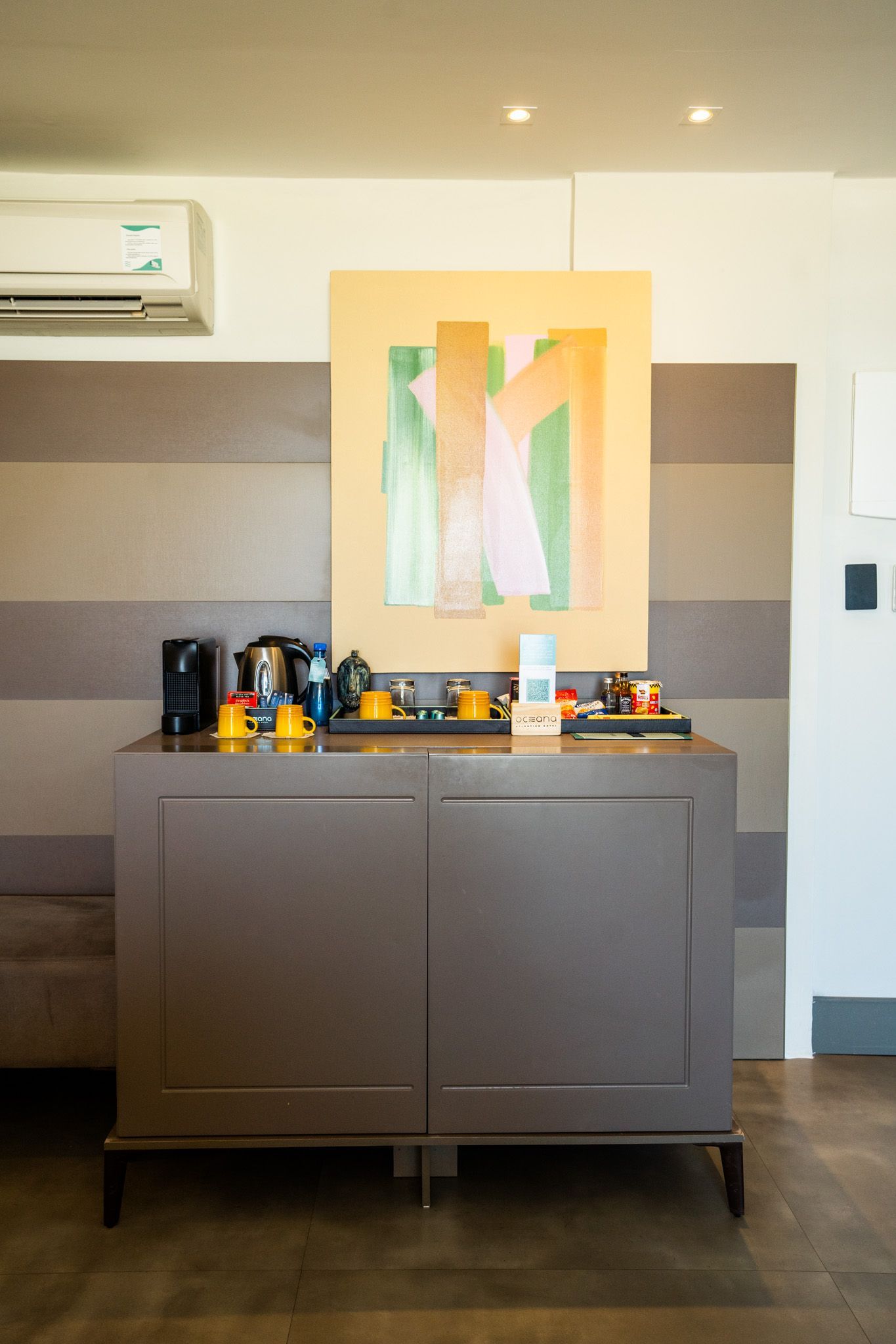 Há uma pintura na parede acima do armário na sala.