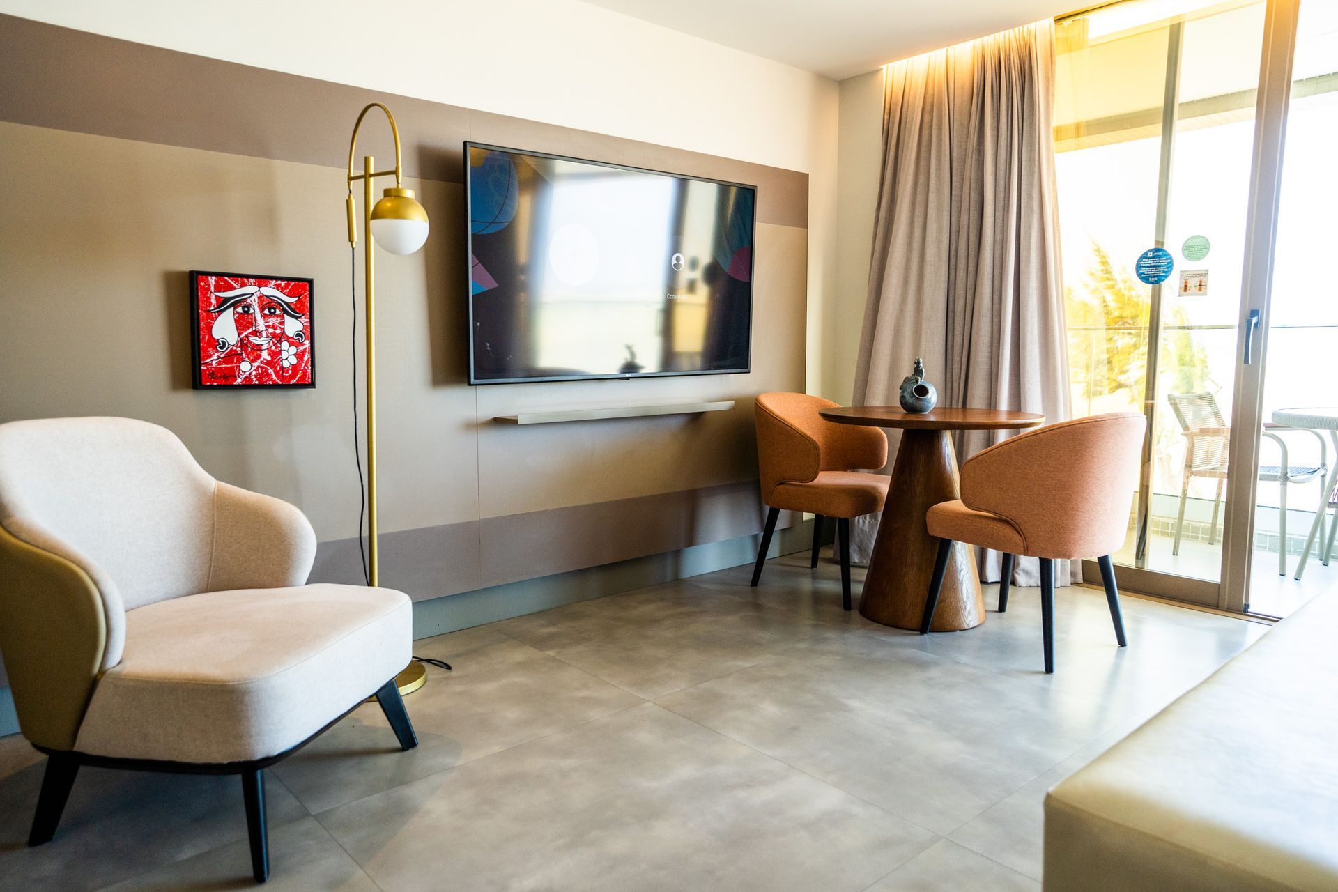 Uma sala de estar com cadeira, mesa e televisão.