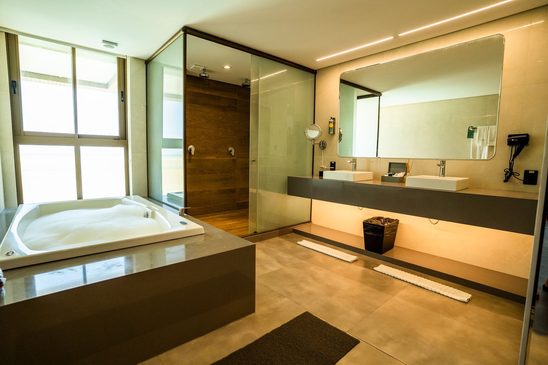 Um banheiro com banheira de hidromassagem e duas pias.