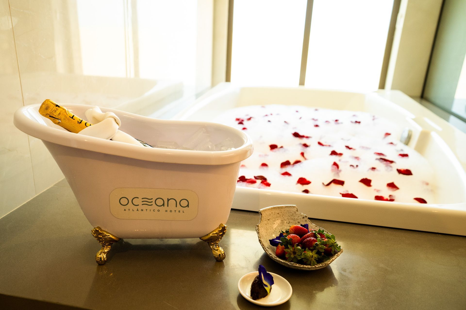 Uma banheira cheia de água e pétalas de rosas ao lado de uma jacuzzi.