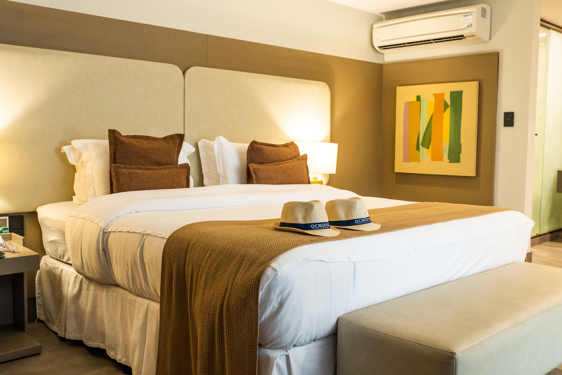 Um quarto de hotel com uma cama grande e uma pintura na parede.