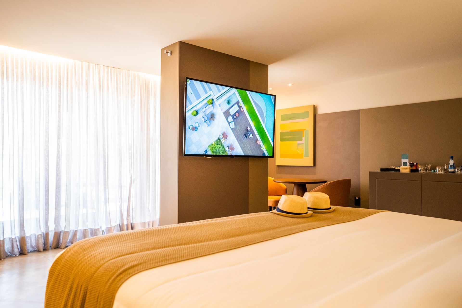 Um quarto de hotel com uma cama grande e uma TV de tela plana na parede.