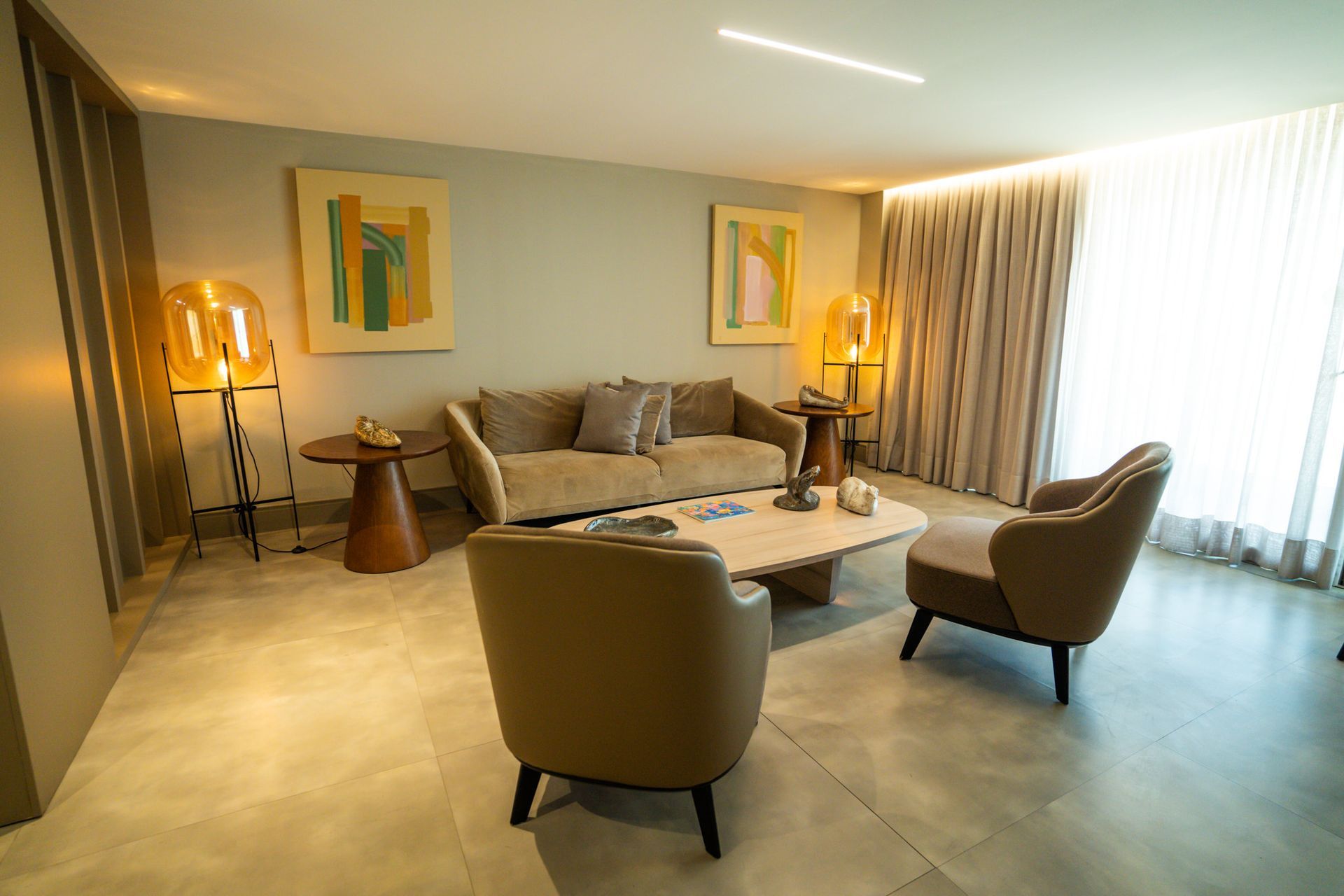 Uma sala de estar com um sofá, cadeiras e uma mesa de centro.