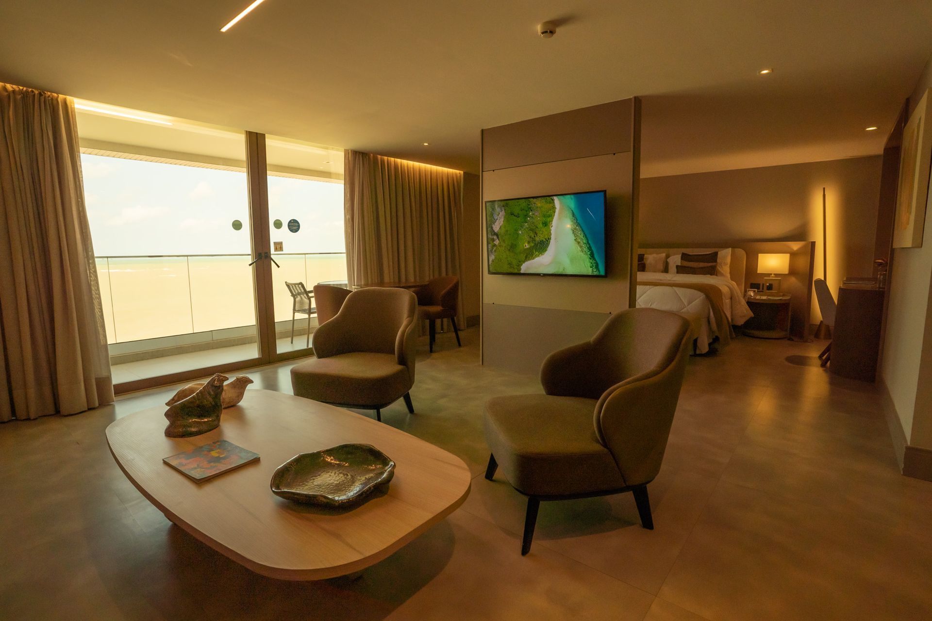 Um quarto de hotel com uma mesa, cadeiras e uma televisão.