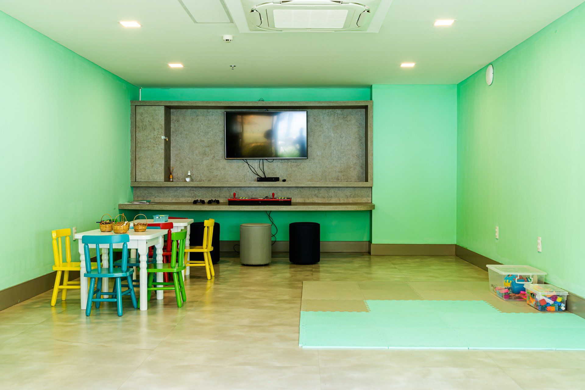 Uma sala para crianças com mesas e cadeiras e uma televisão.