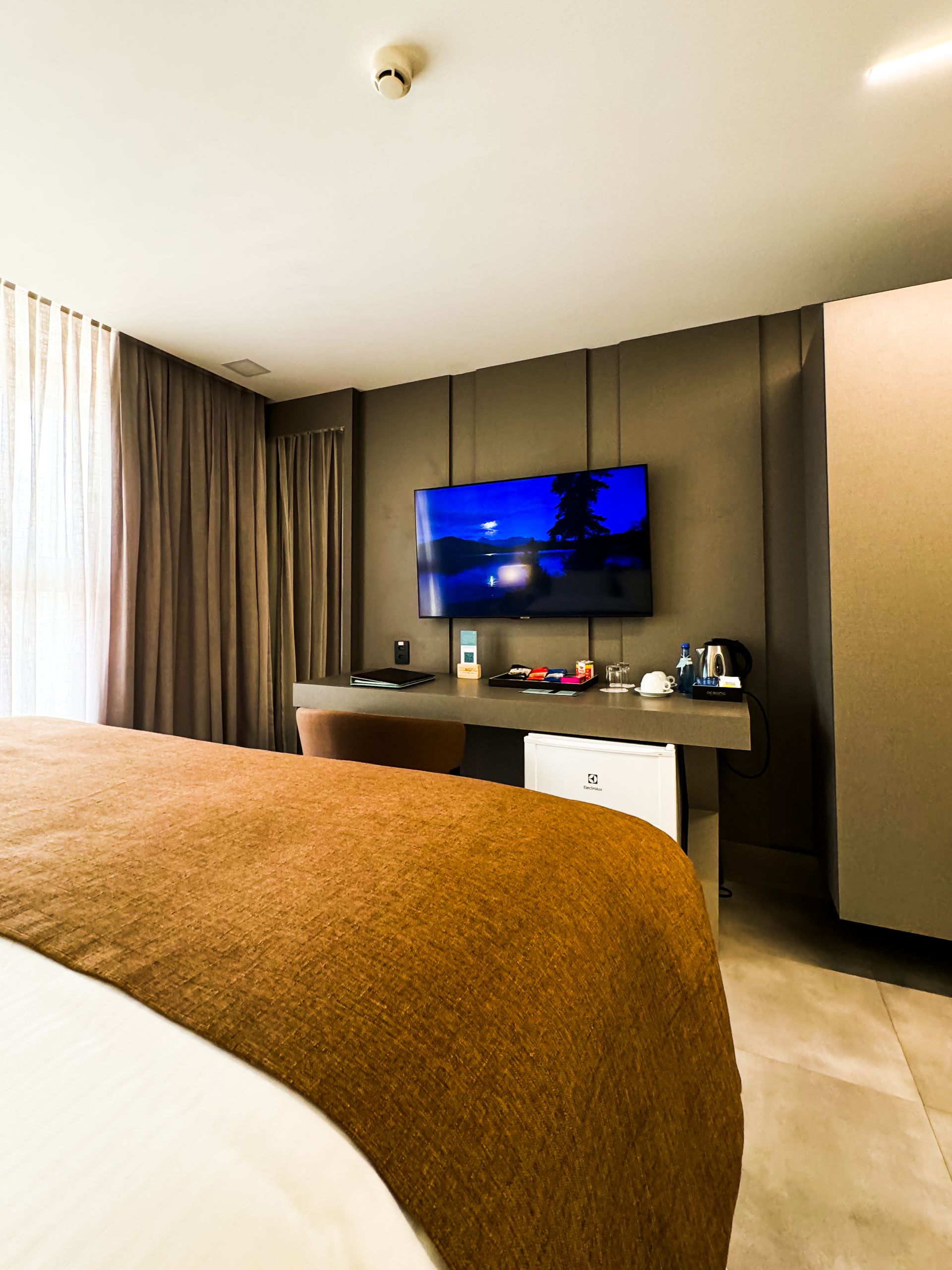 Um quarto de hotel com uma cama e uma TV de tela plana