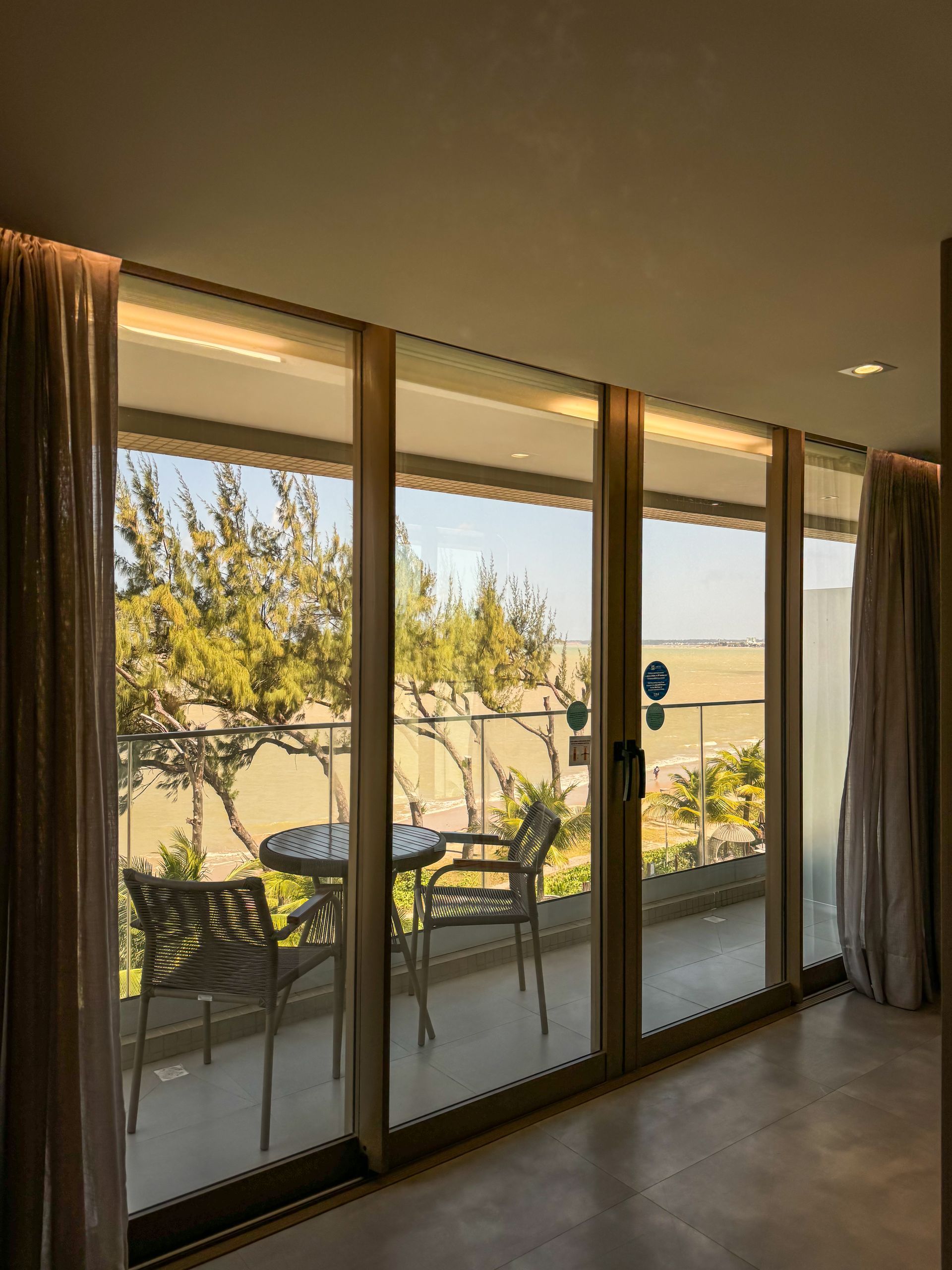 Há uma varanda com mesa e cadeiras no quarto.