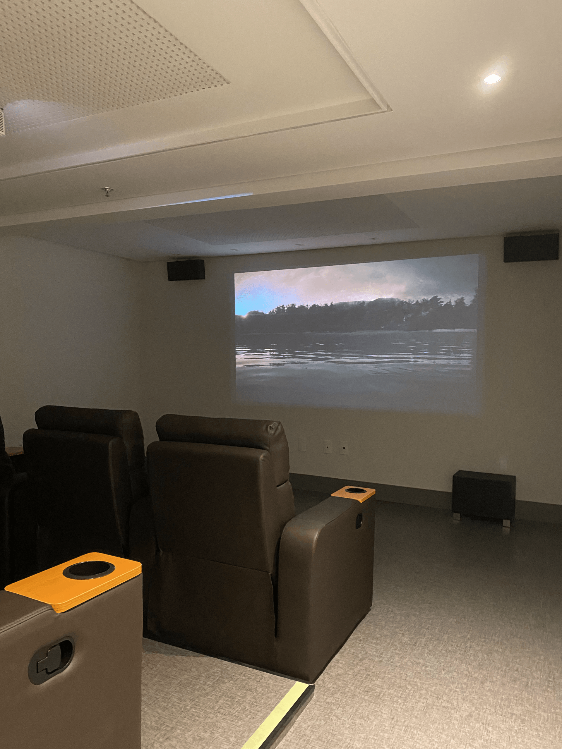 Um home theater com tela de projetor e cadeiras