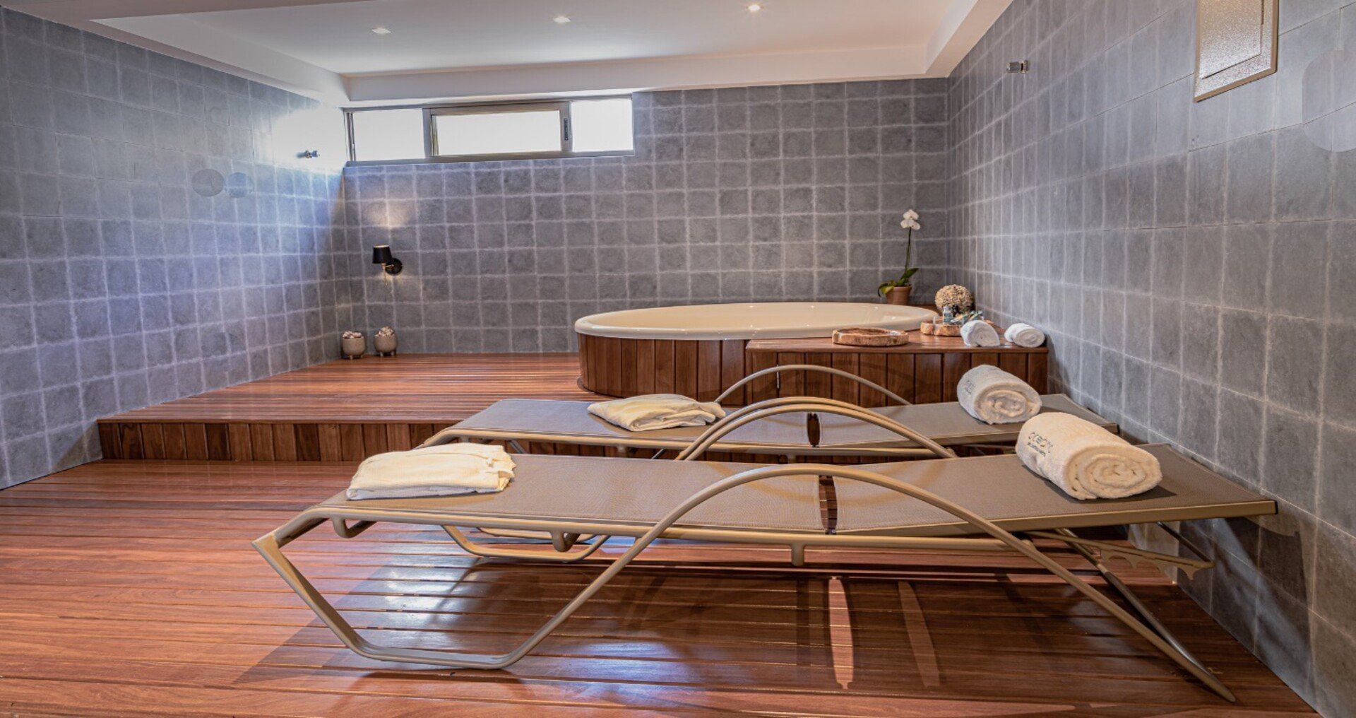 Há duas espreguiçadeiras em uma sala com jacuzzi.