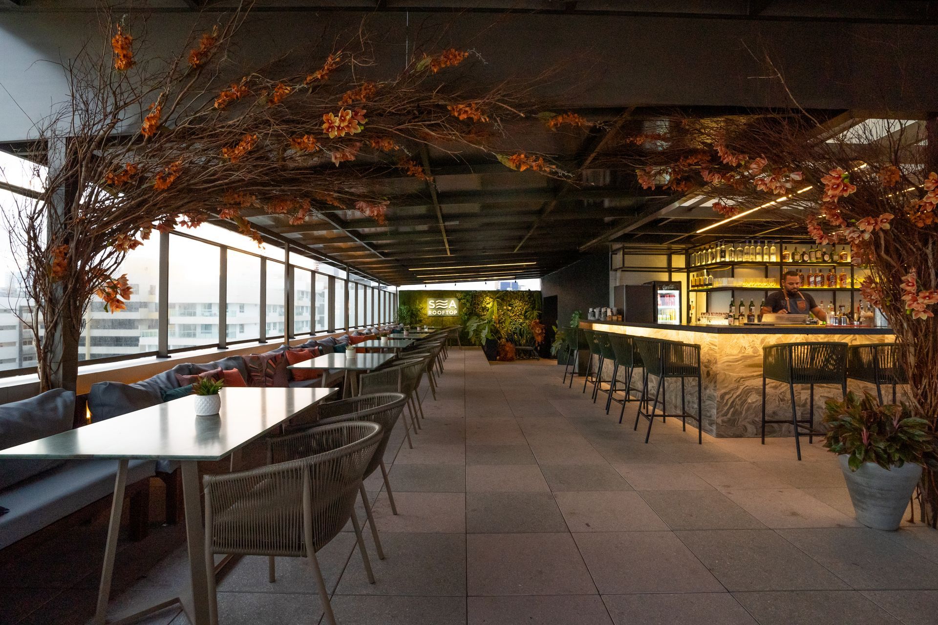 Um restaurante com mesas e cadeiras e um bar.