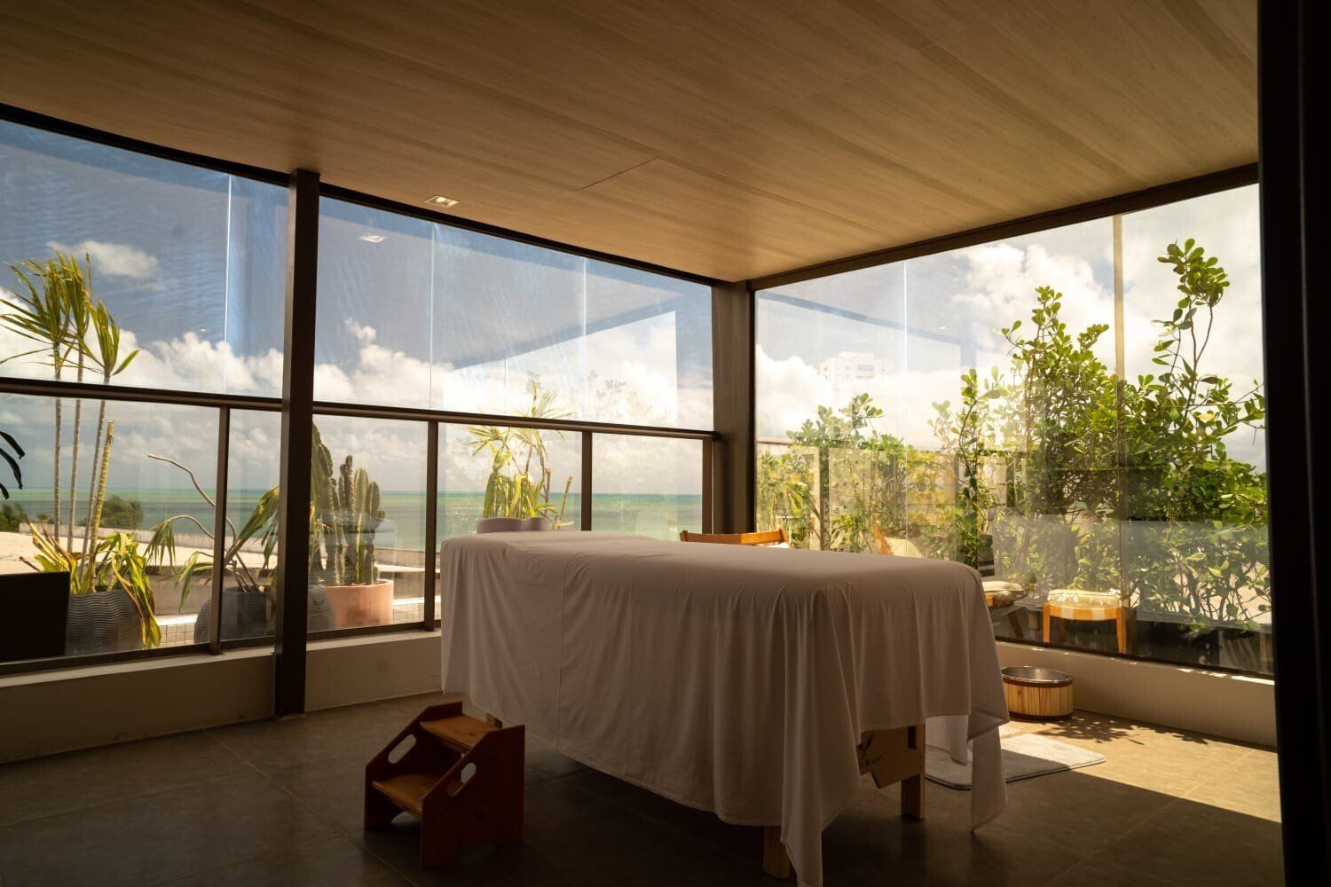 Uma mesa de massagem em uma varanda com vista para o oceano.
