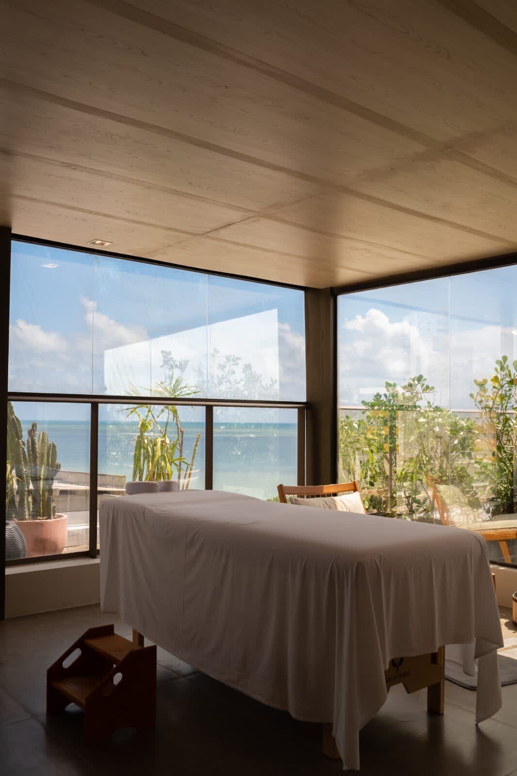 Uma mesa de massagem em uma sala com vista para o oceano.