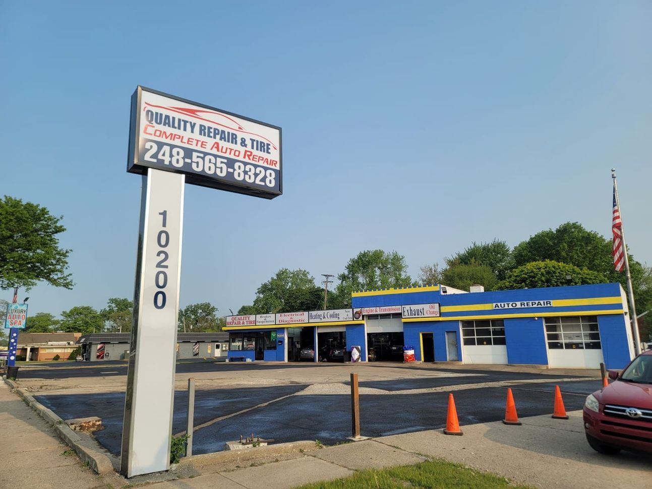 Blue auto repair shop with a large sign displaying 