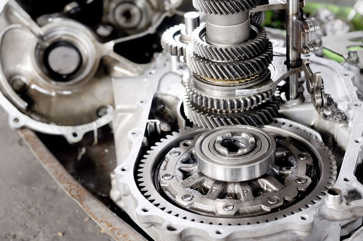 An open automotive transmission case showing internal gears, shafts, and a bearing assembly during repair or inspection.
