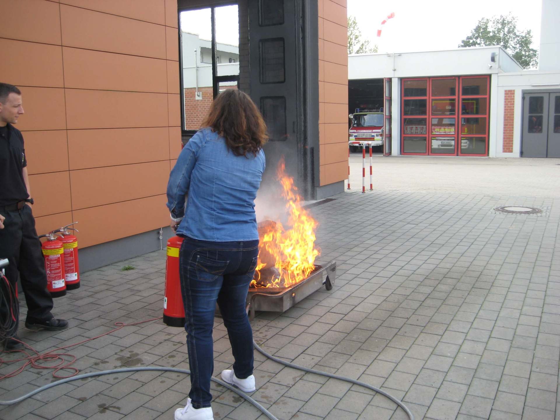 Eine Frau benutzt einen Feuerlöscher, um ein Feuer zu löschen