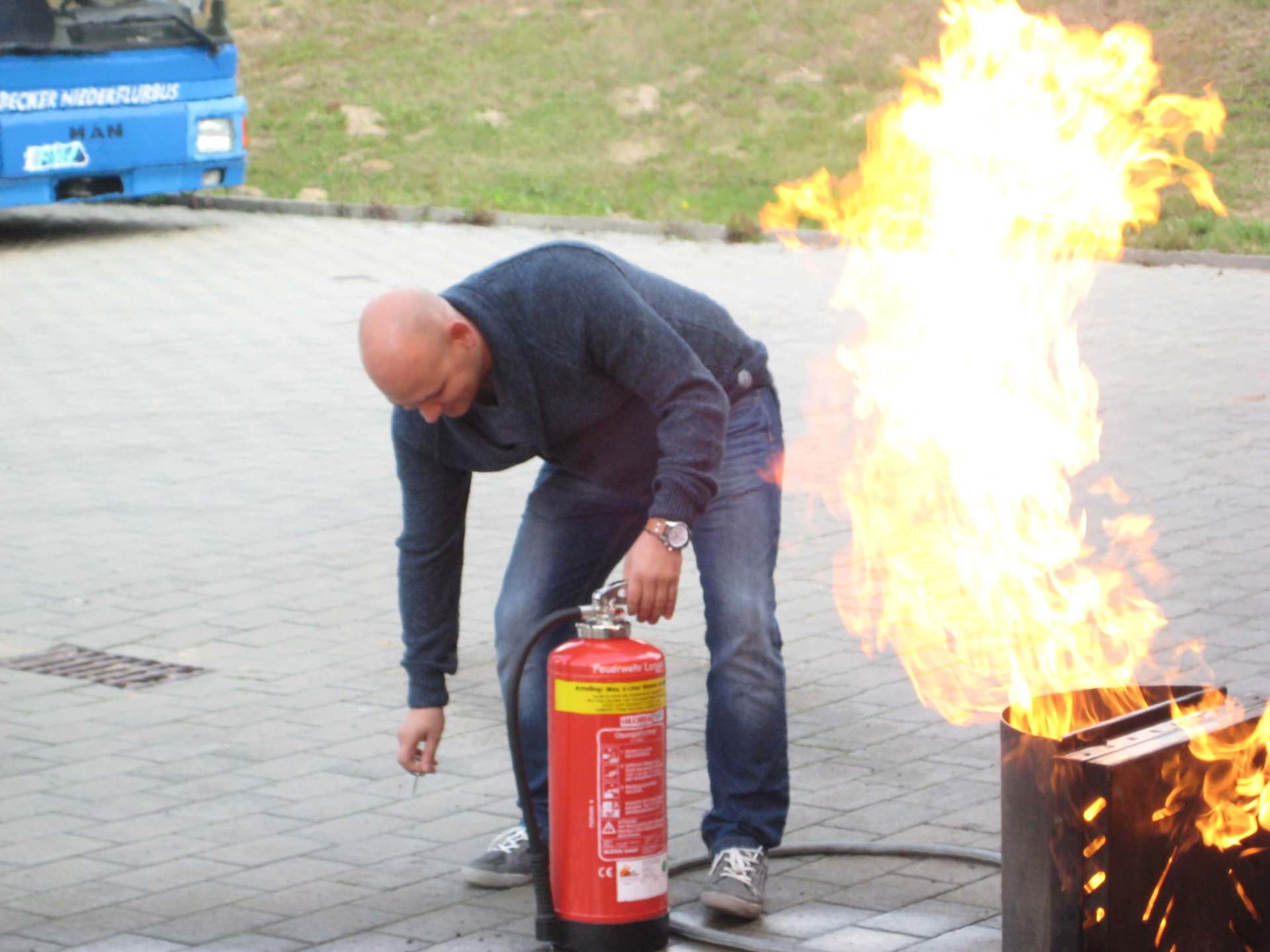 Ein Mann benutzt einen Feuerlöscher, um ein Feuer zu löschen