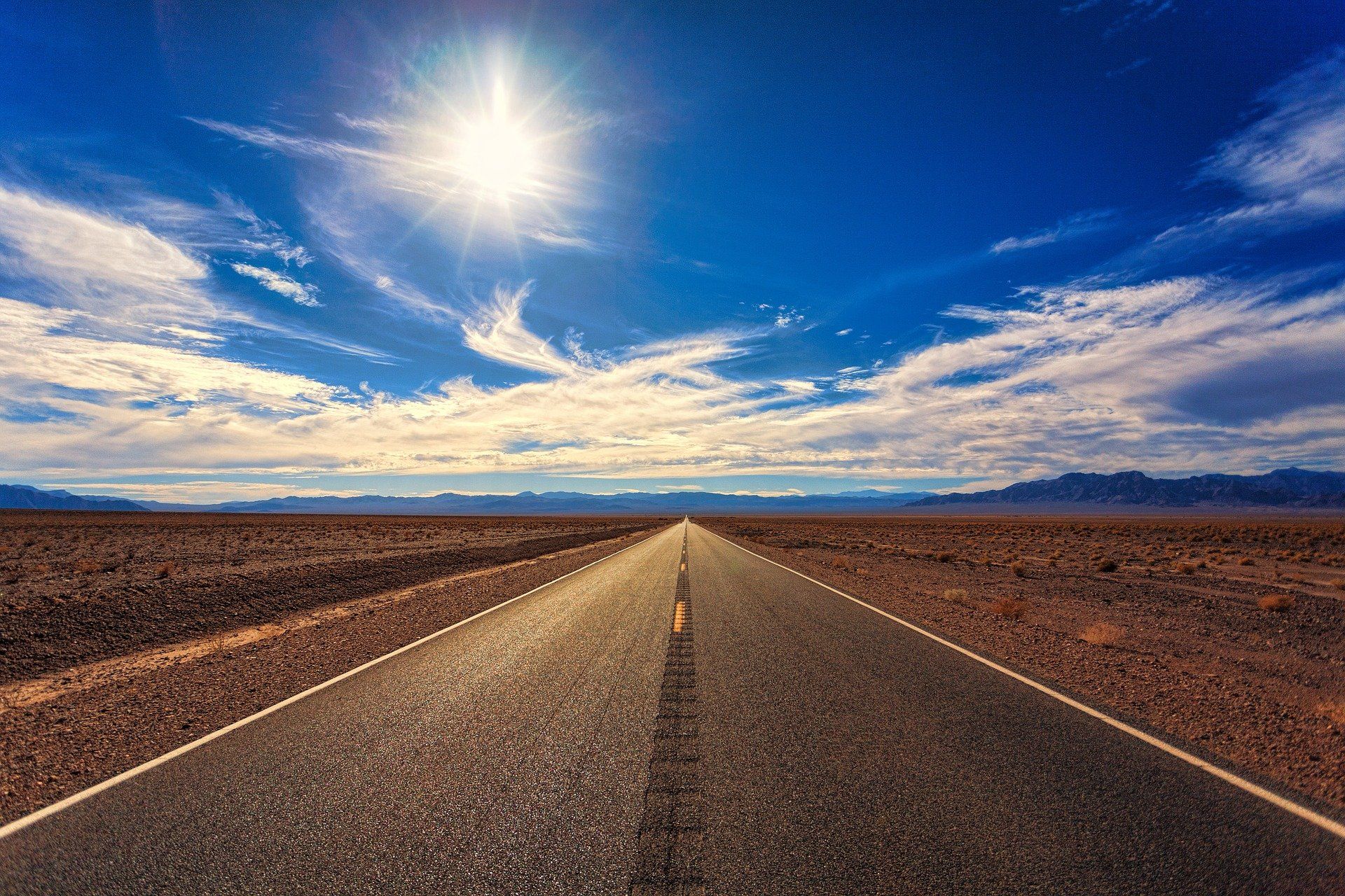 Die Sonne scheint hell über einer Wüstenstraße