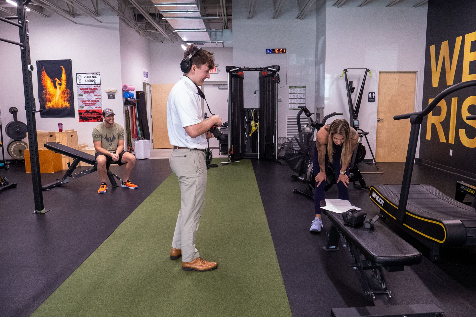 Woman smiles while preparing food in a kitchen with fruit and plants.