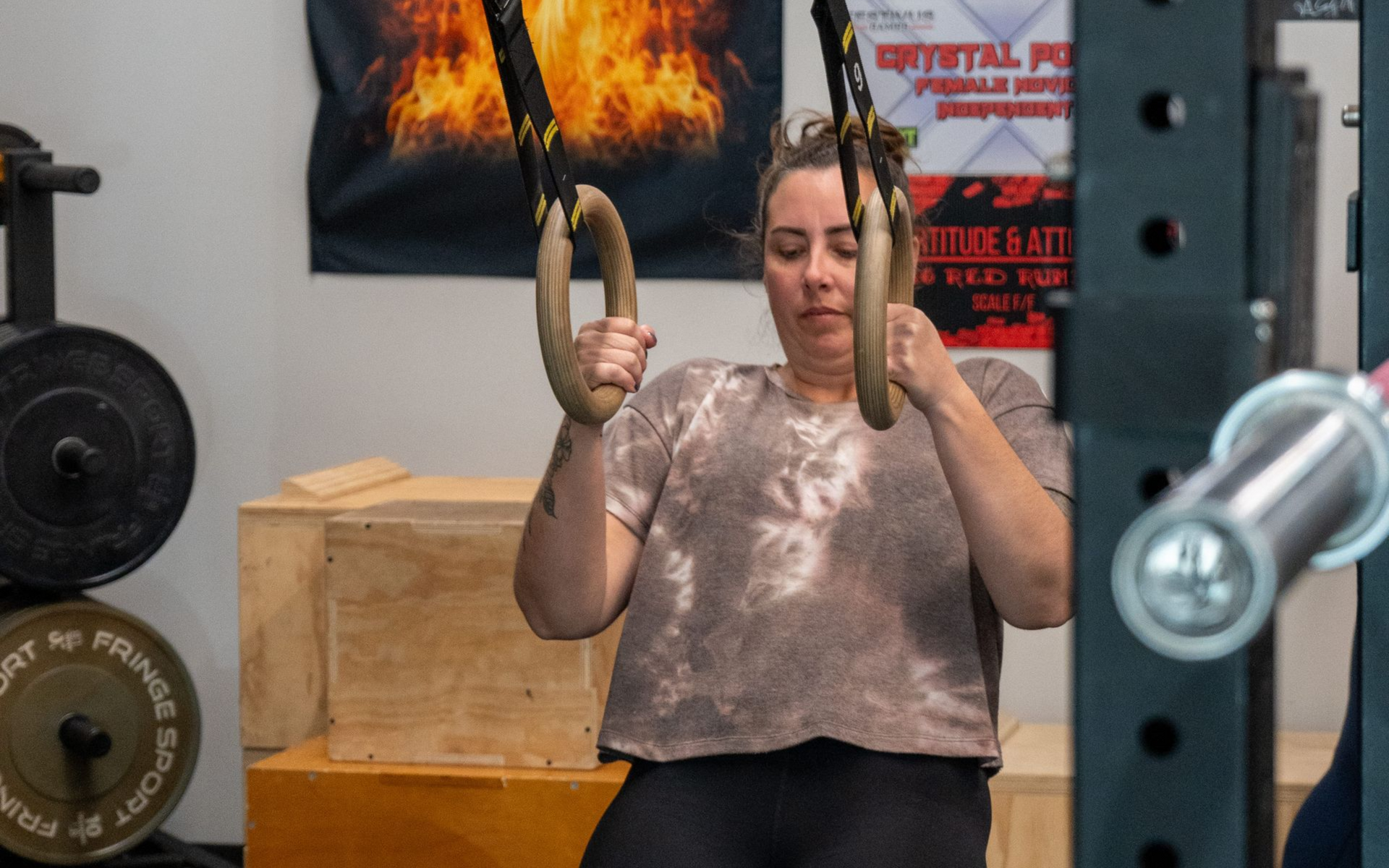 Group of people in a gym, posing. Holding a medicine ball, smiling. Workout setting with equipment.