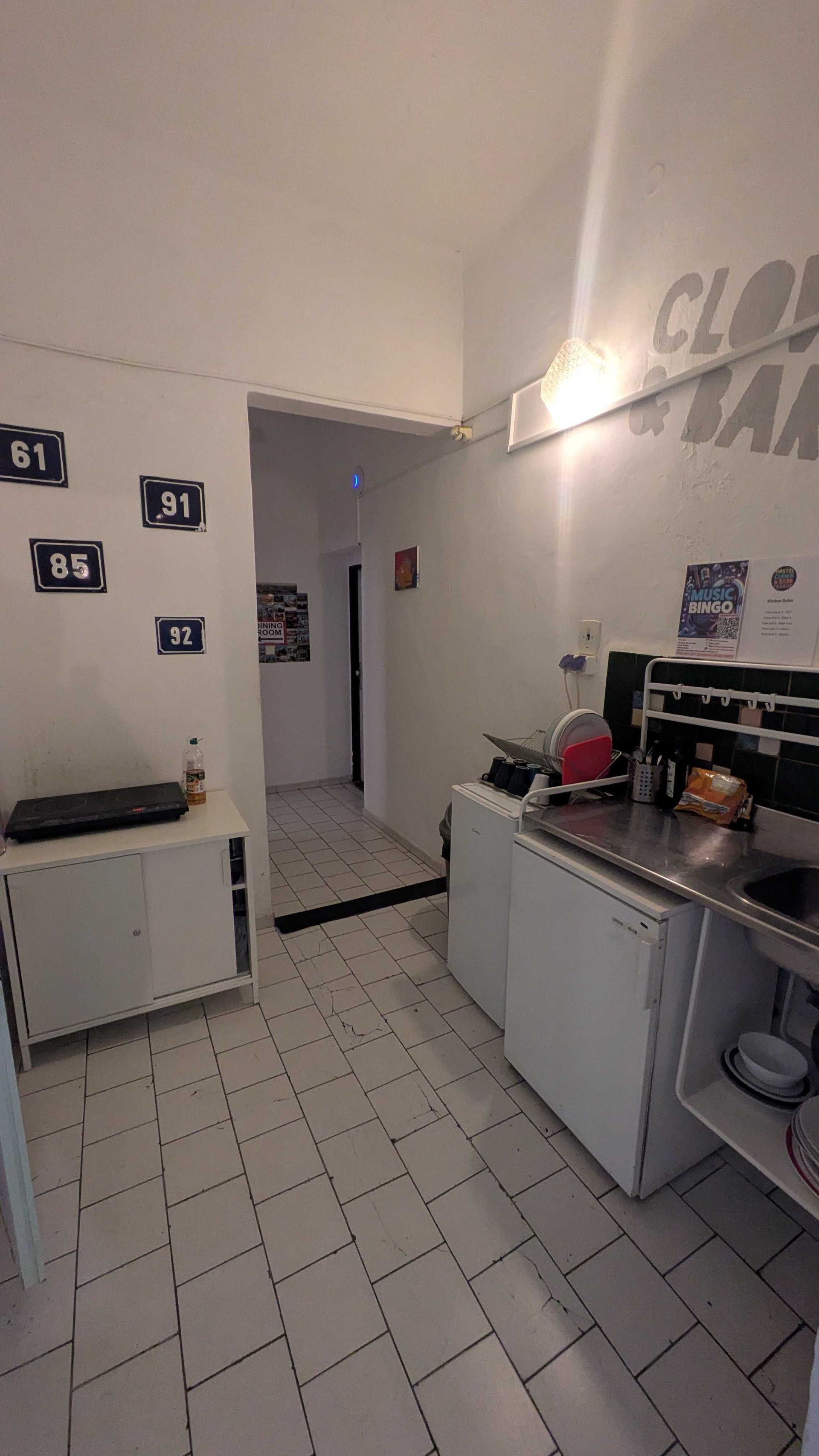 Small kitchen with white cabinets, appliances, and tile floor.