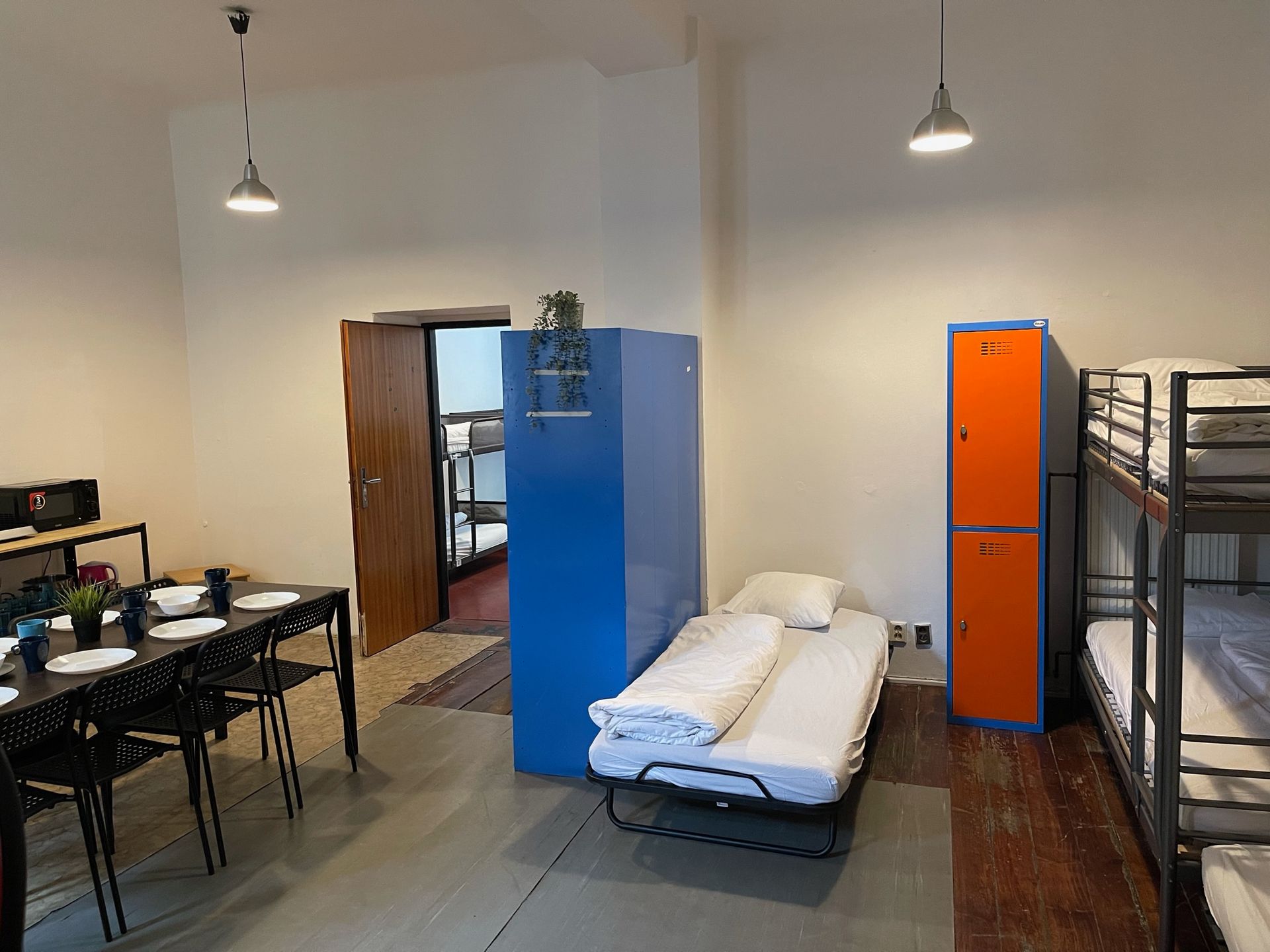 Shared hostel room with bunk beds, lockers, and dining table