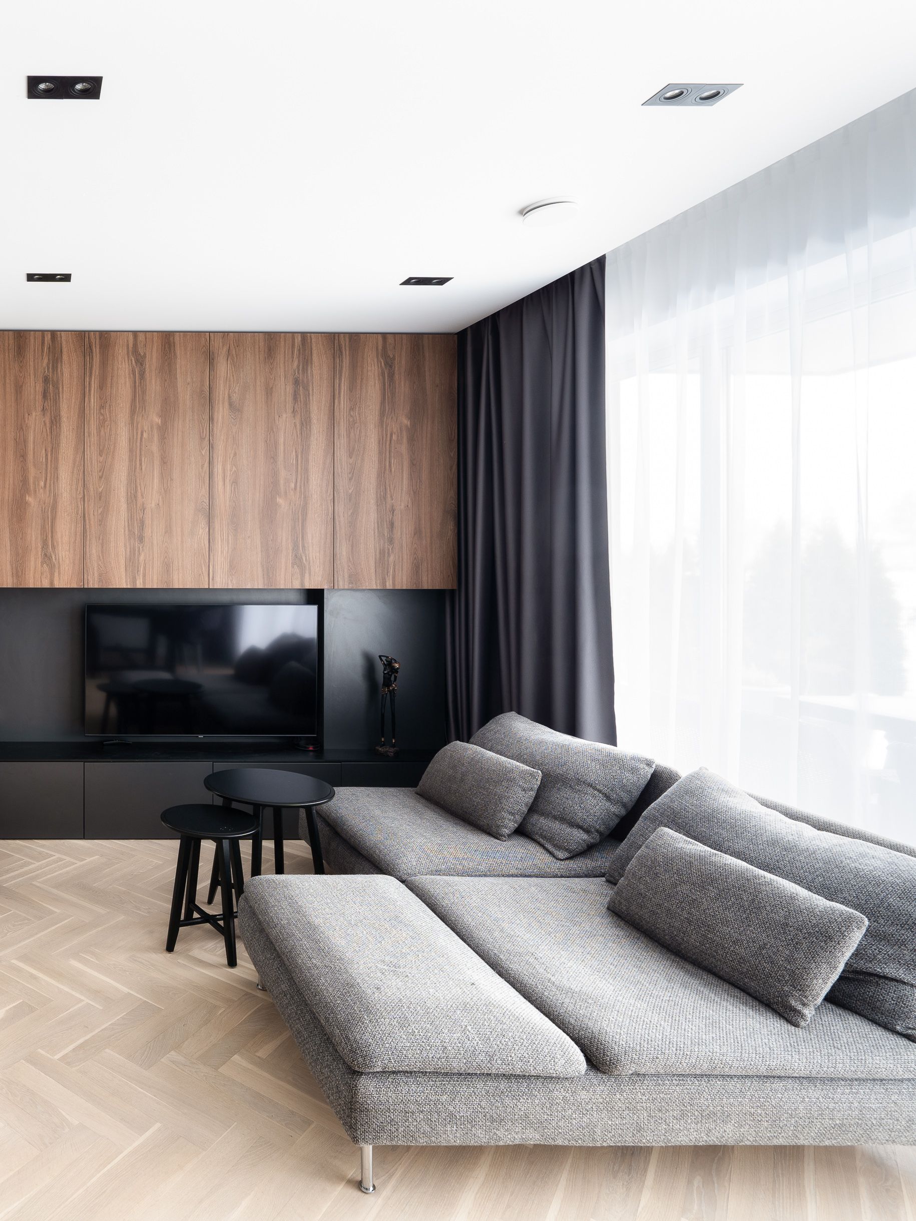 Svetainė su sofa ir plokščiaekraniu televizoriumi.