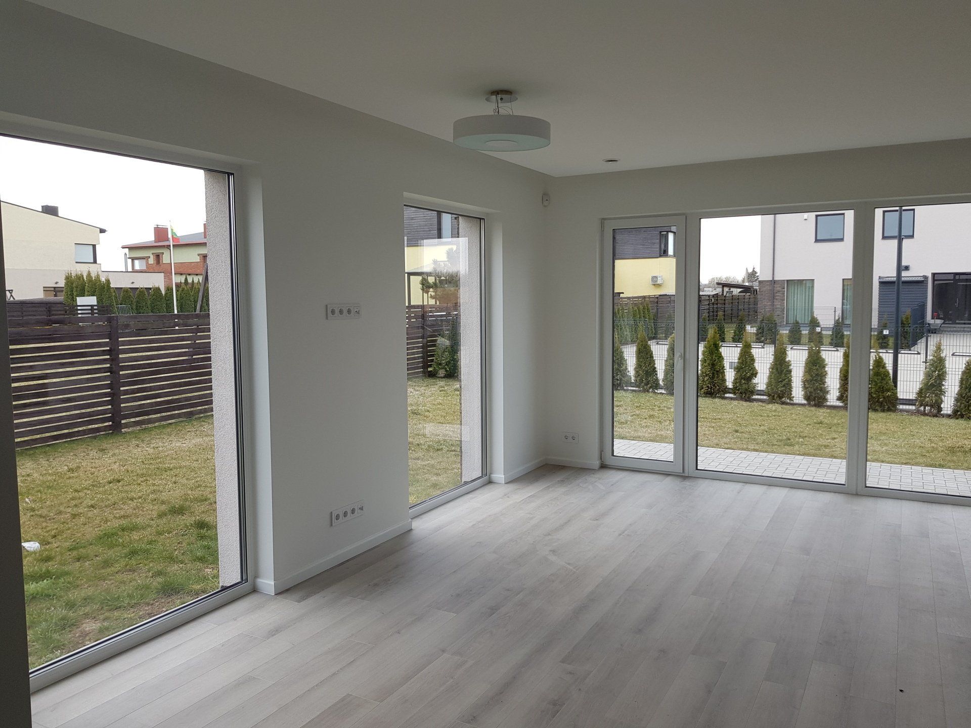 svetainė su daugybe langų ir lubų šviestuvu.