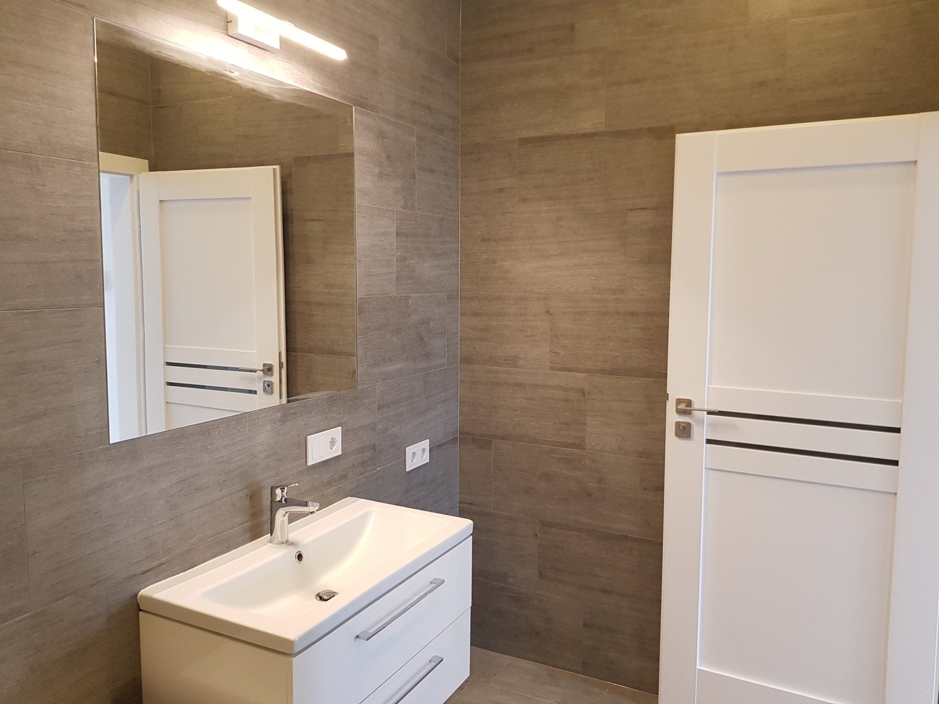 Vonios kambarys su kriaukle, veidrodžiu ir durimis