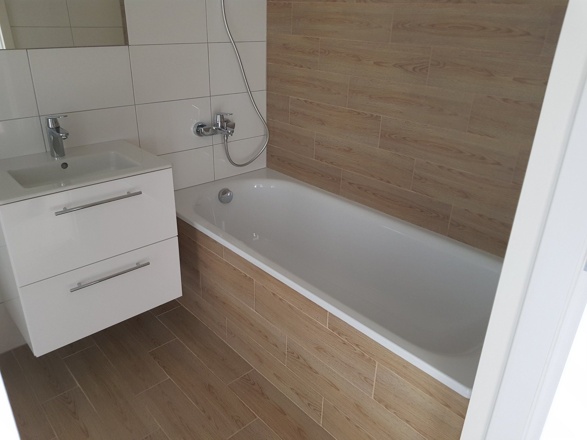 Vonios kambarys su vonia, kriaukle ir veidrodžiu