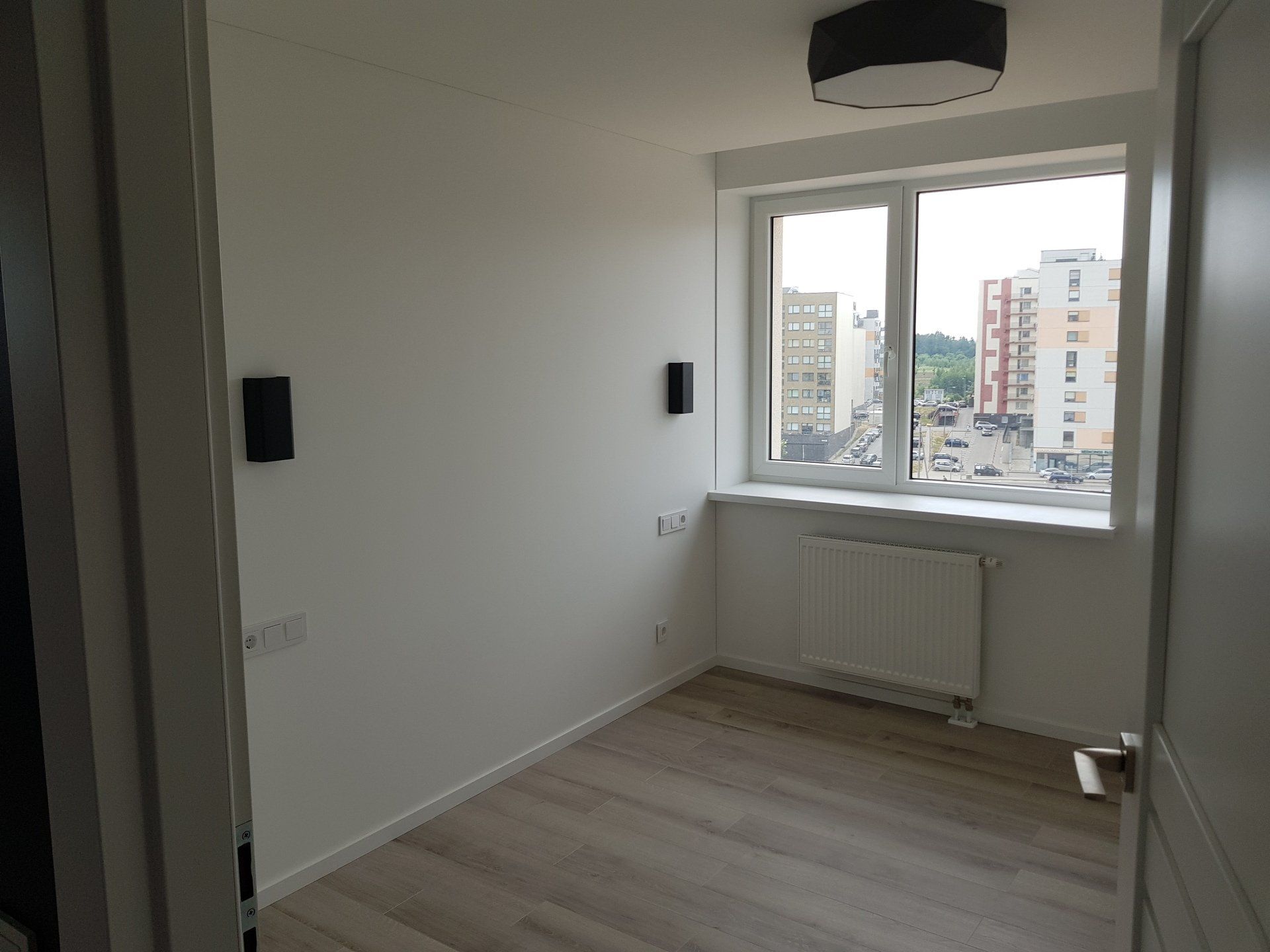 Tuščias kambarys su langu ir radiatoriumi