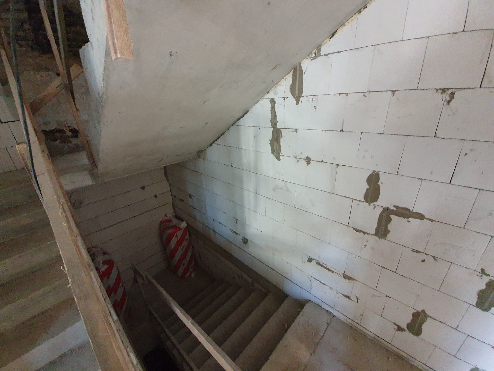 Laiptai, vedantys į baltų plytų sieną.