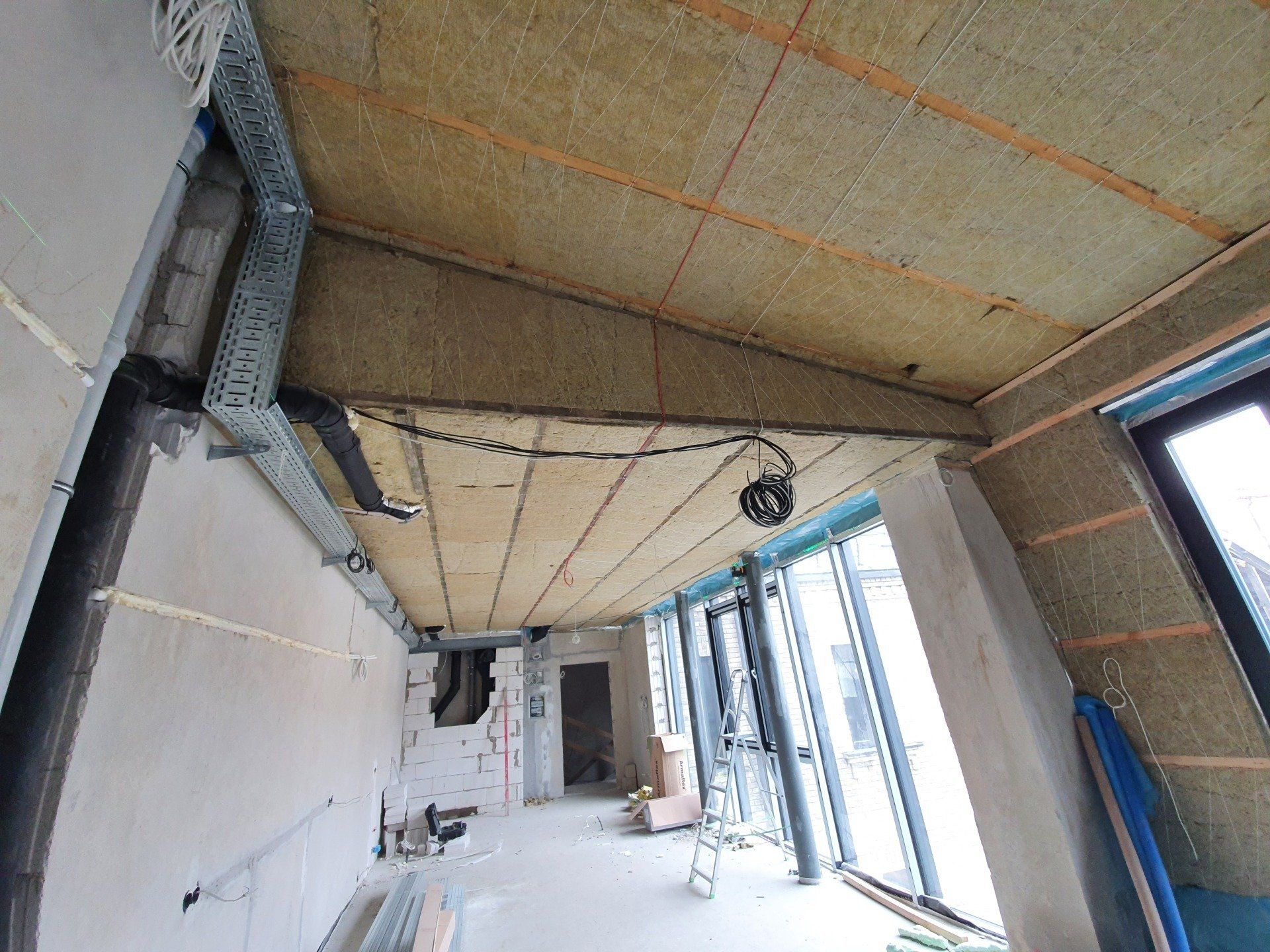 Kambarys su statomomis lubomis ir daugybe langų.