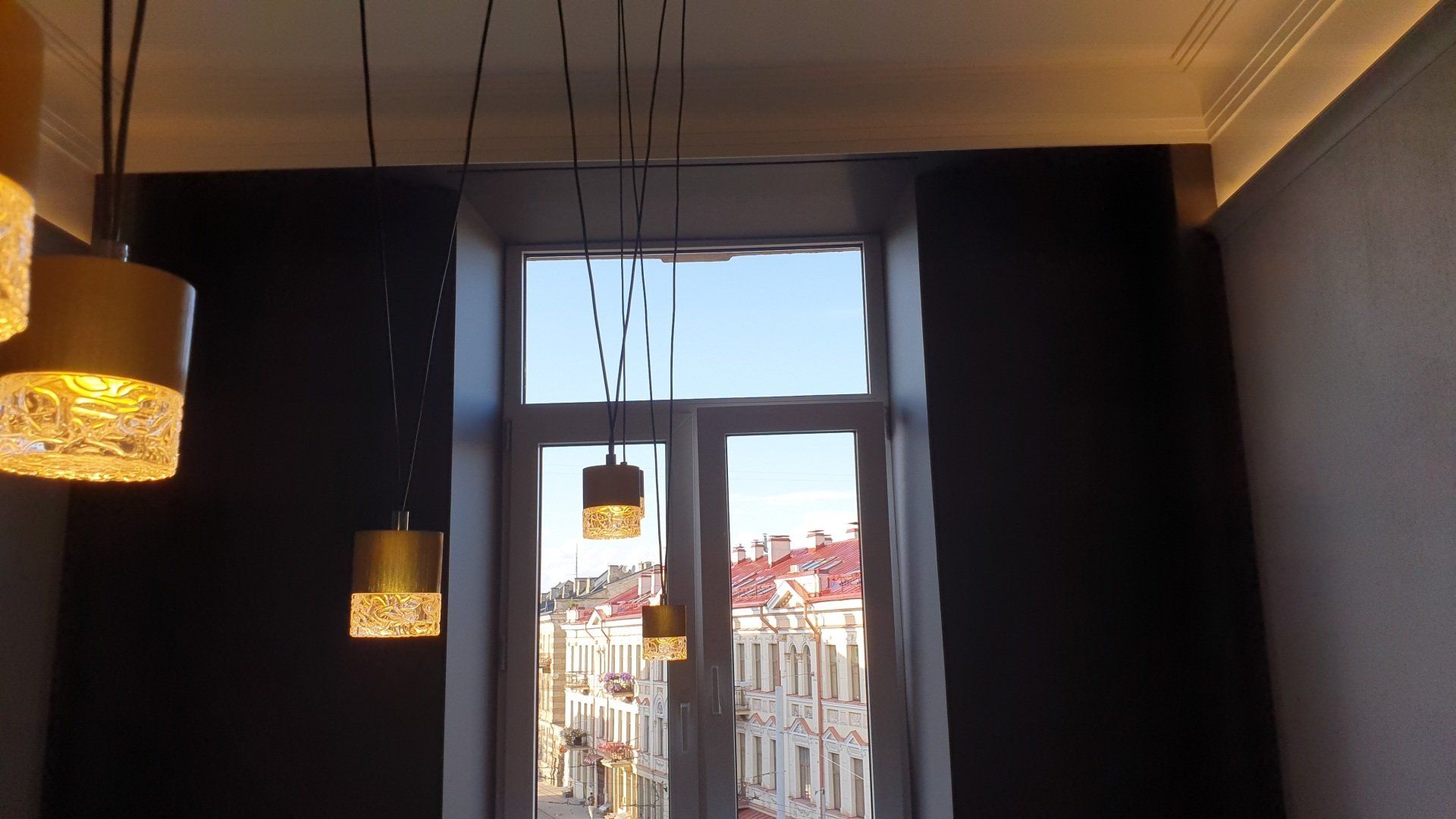 Kambarys su langu ir nuo lubų kabančiomis lempomis