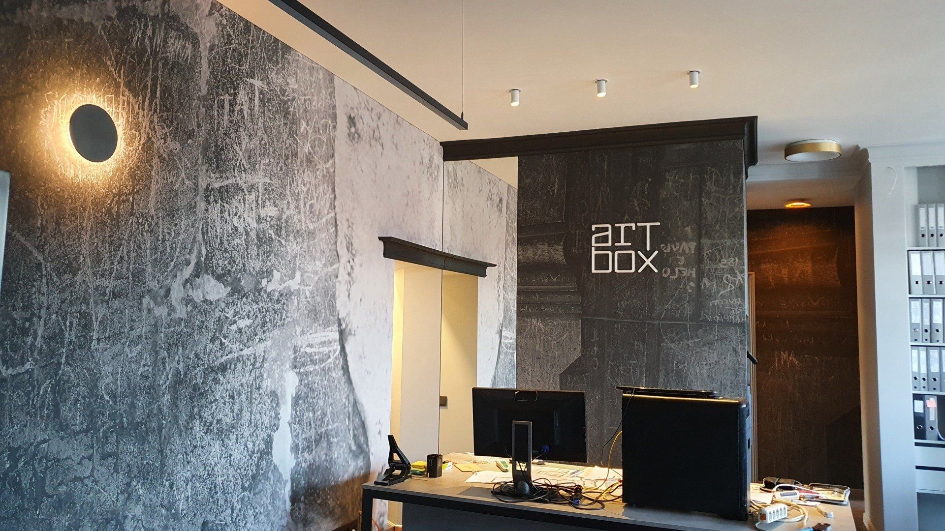 Kambarys su siena, ant kurios užrašyta „meno dėžutė“