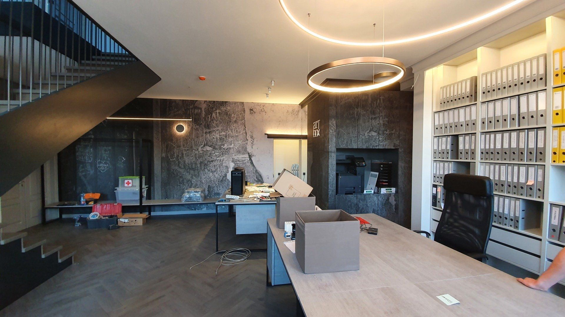 Tuščias biuras su stalu, kėdėmis ir laiptais