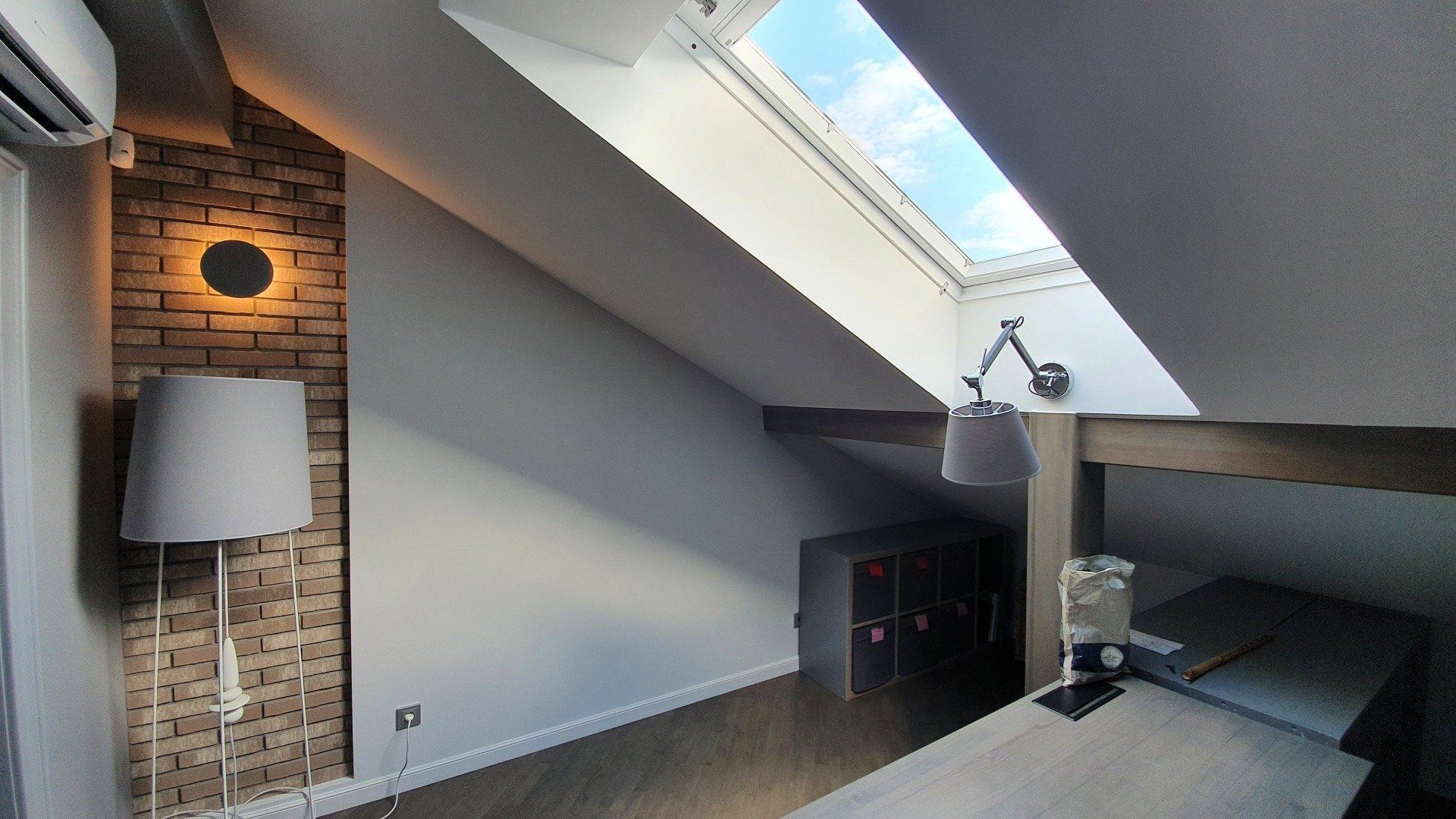 Miegamasis su stoglangiu ir lempa ant sienos