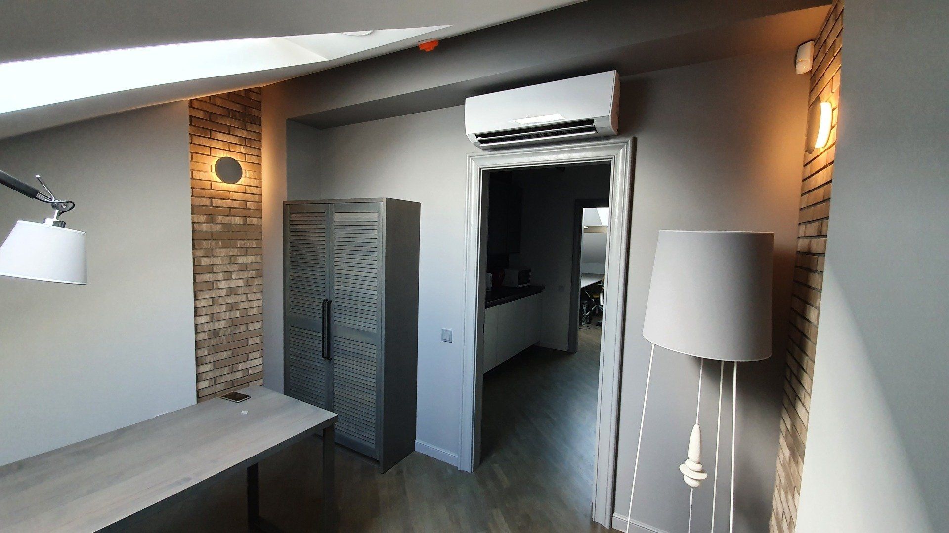 Kambarys su stalu ir lempa jame