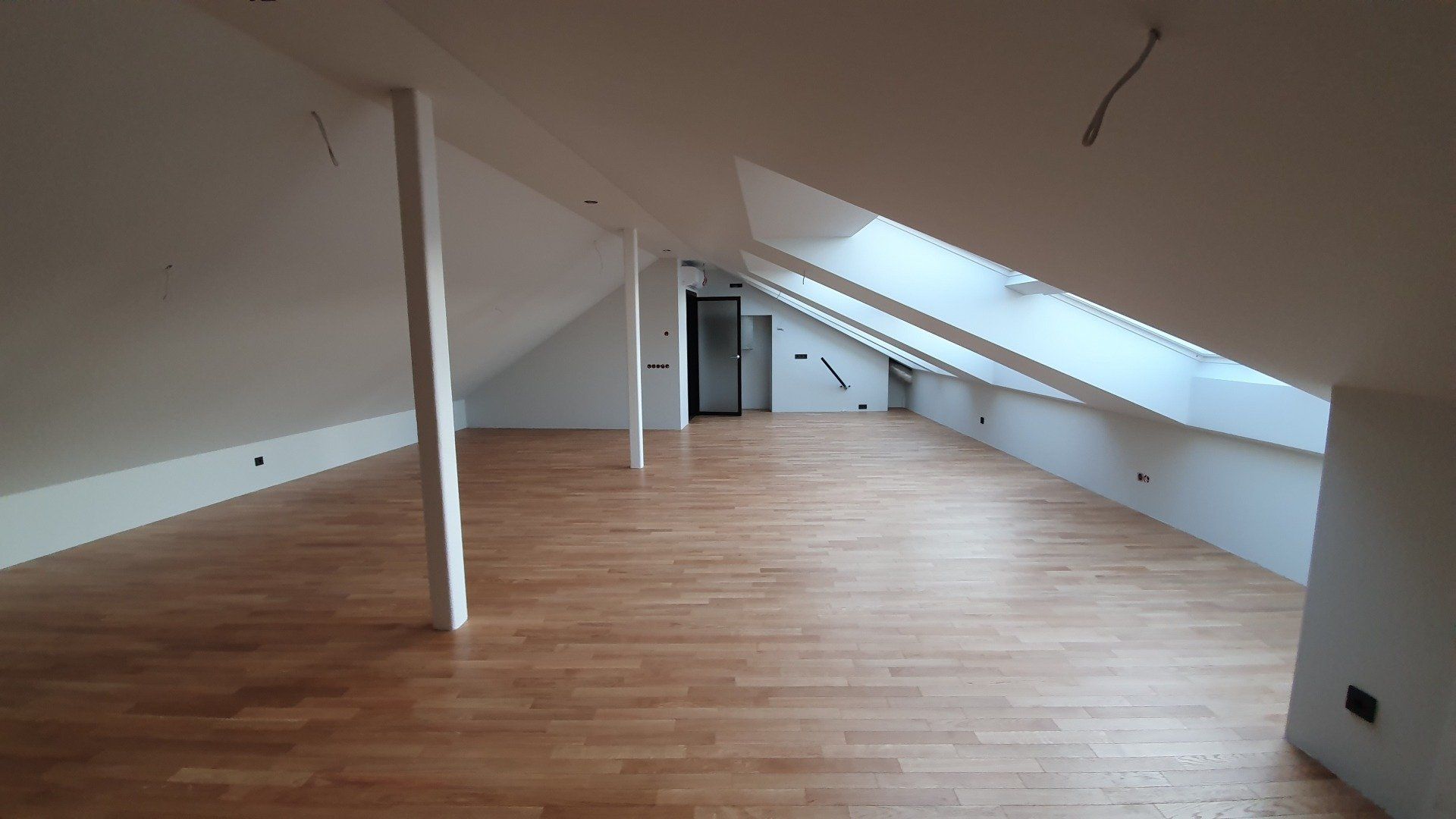 Tuščia palėpė su medinėmis grindimis ir baltomis sienomis