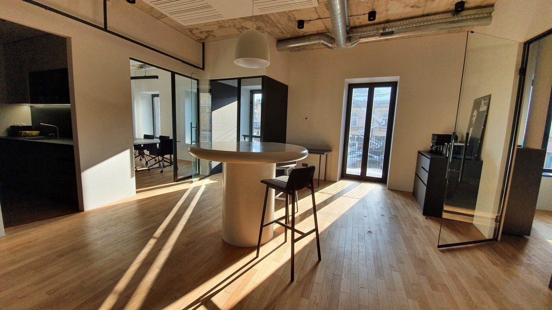 Didelis kambarys su stalu ir kėdėmis jame.