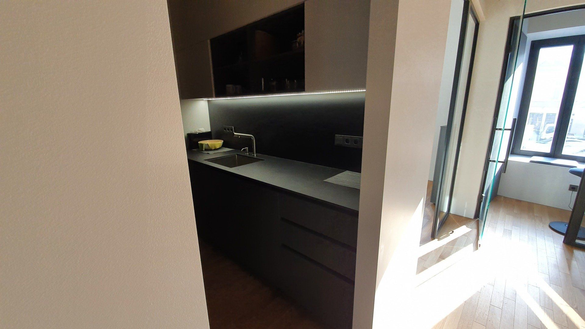 Virtuvė su kriaukle, spintelėmis ir langu