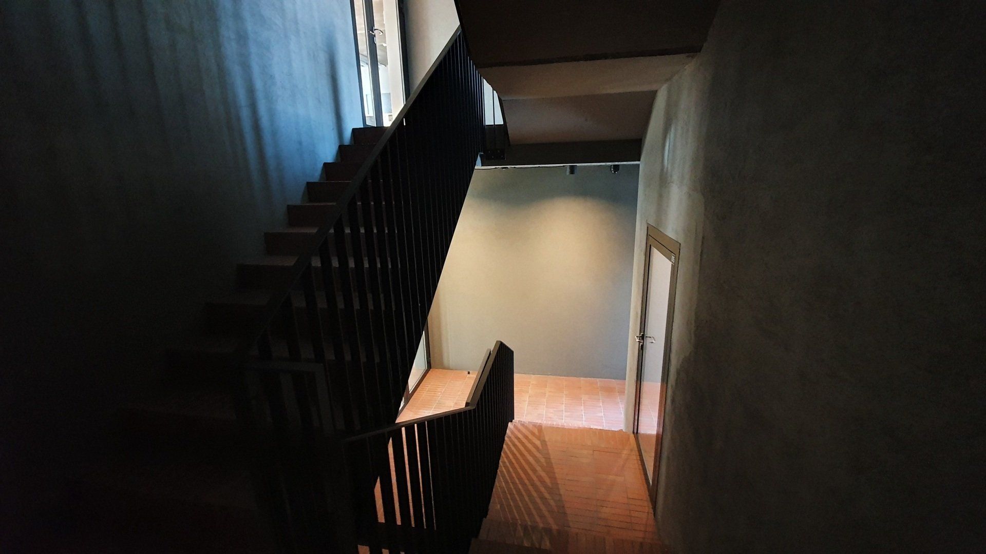 Tamsus koridorius su laiptais, vedančiais į antrą aukštą.