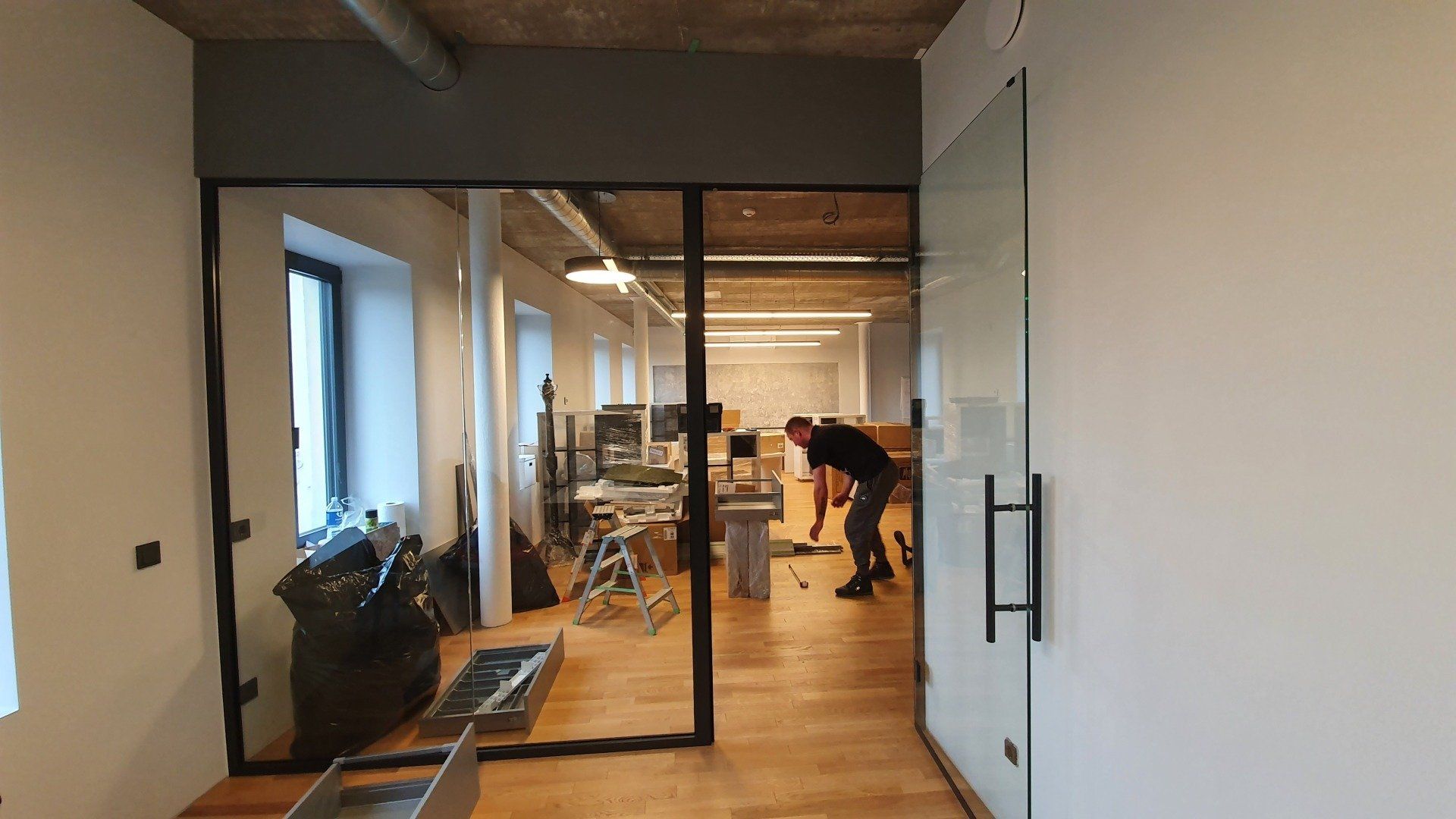 Vyras dirba prie stiklinių durų kambaryje.