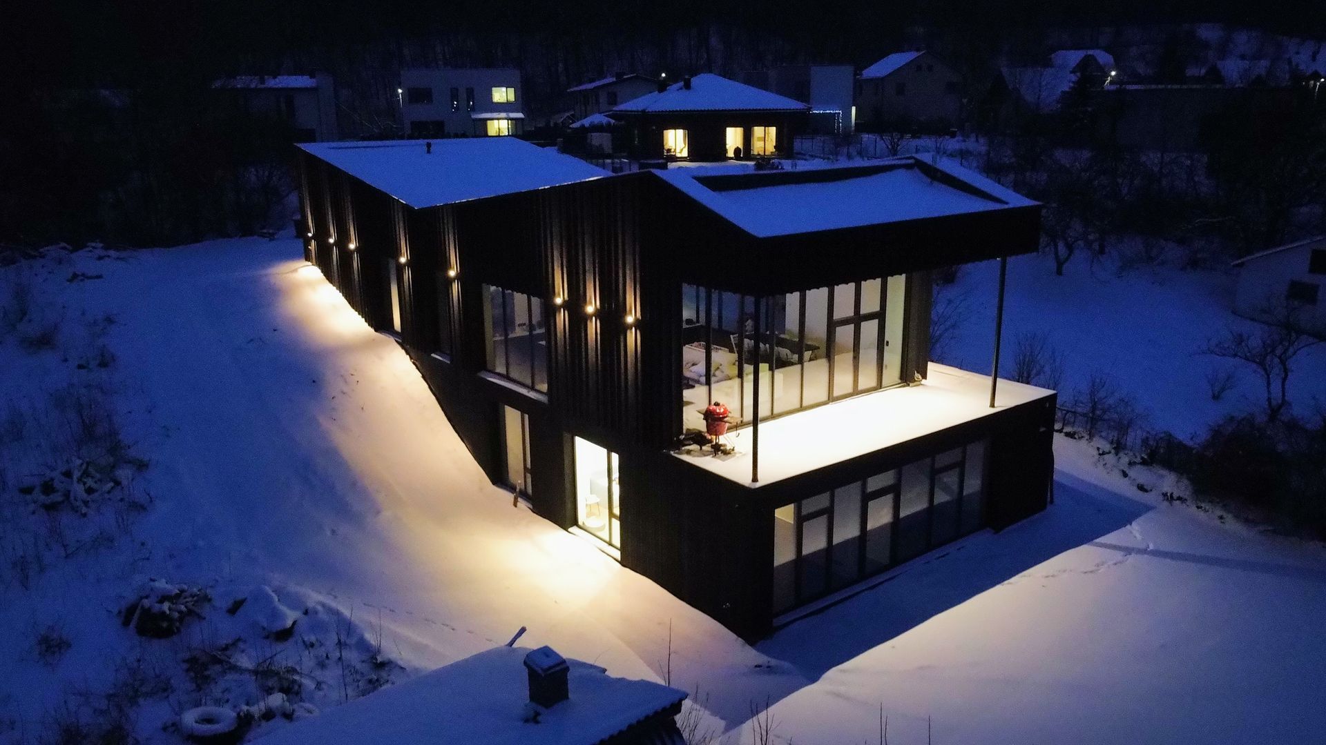 Namo sniege vaizdas iš oro naktį.