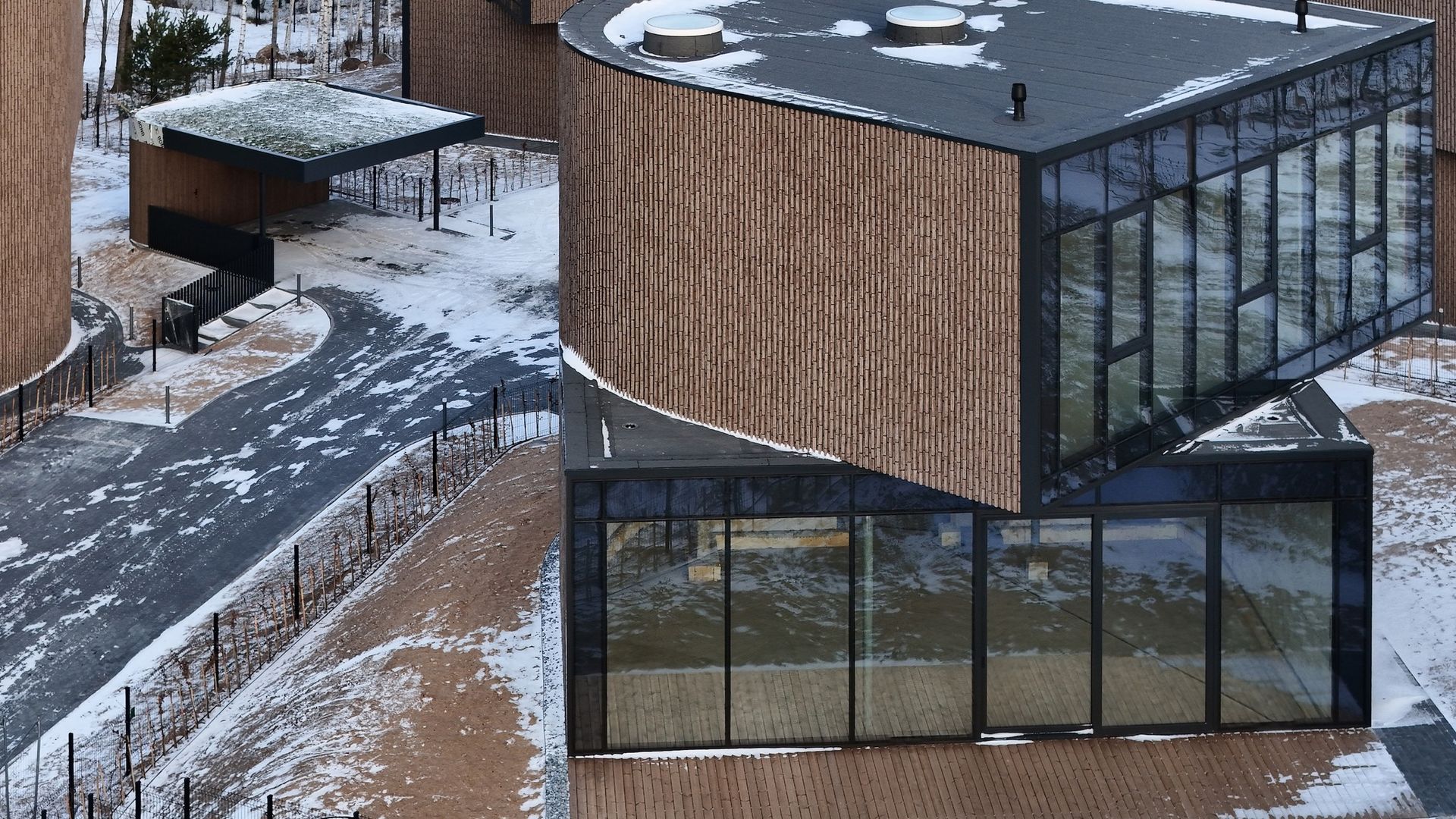 Didelis pastatas su daugybe langų yra apsuptas sniego