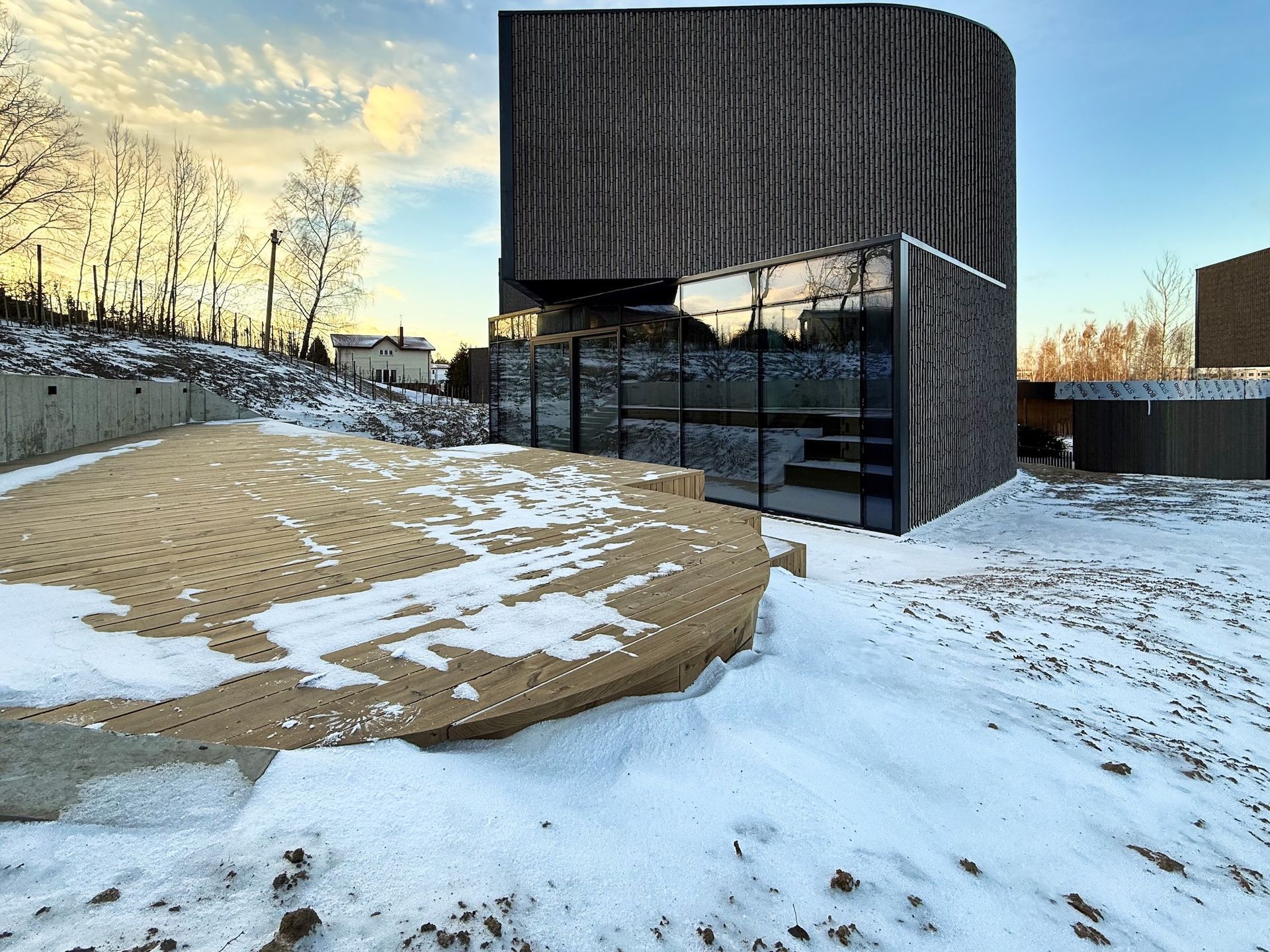 Didelis pastatas stovi apsnigto lauko viduryje.