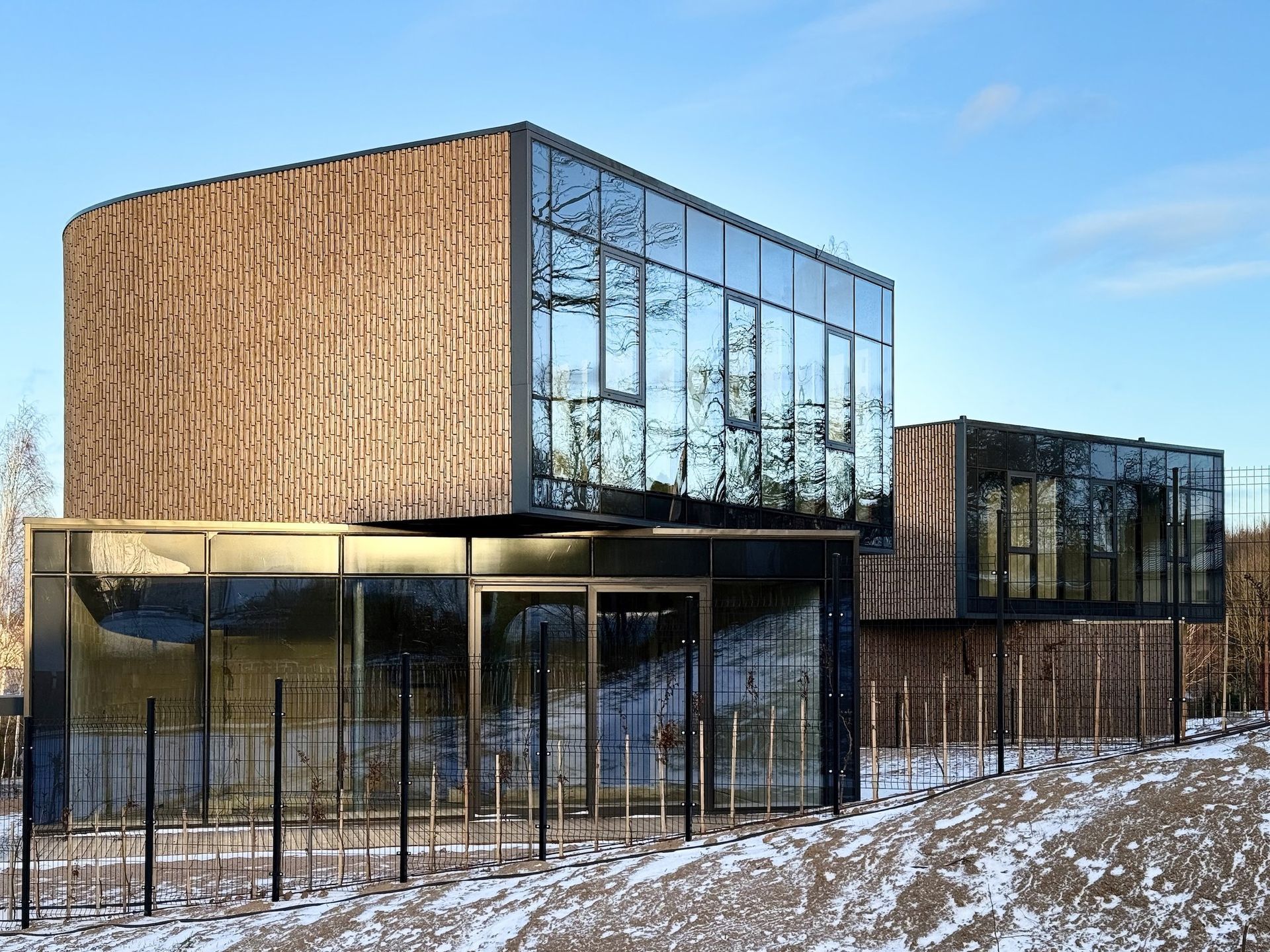 Pastatas su daugybe langų ir mediniu fasadu