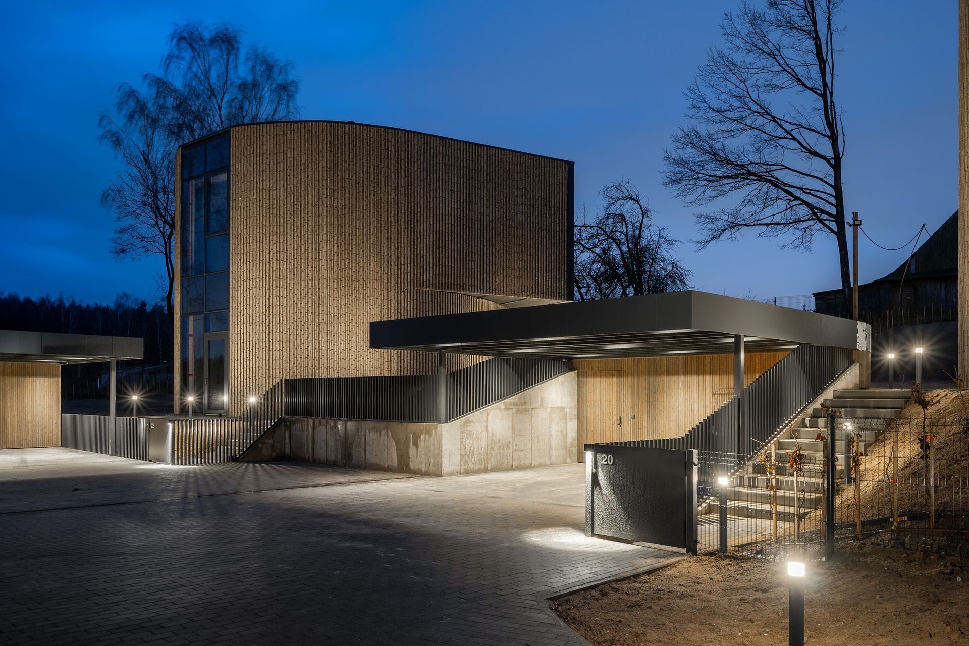 Naktį apšviestas didelis pastatas su į jį vedančiais laiptais.