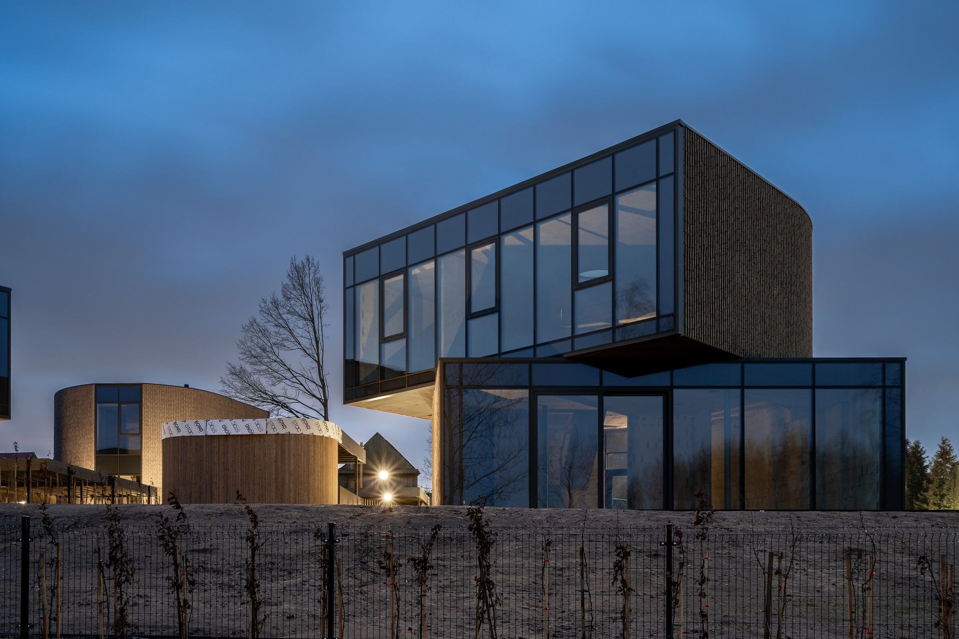 Modernus namas su daugybe langų ir tvora priešais jį.