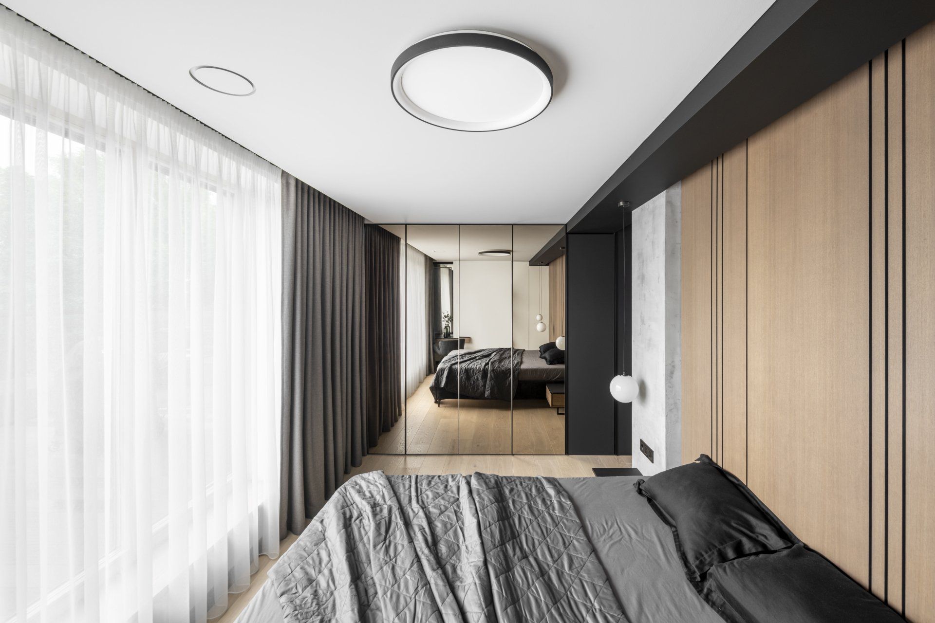 Miegamasis su didele lova ir dideliu langu.